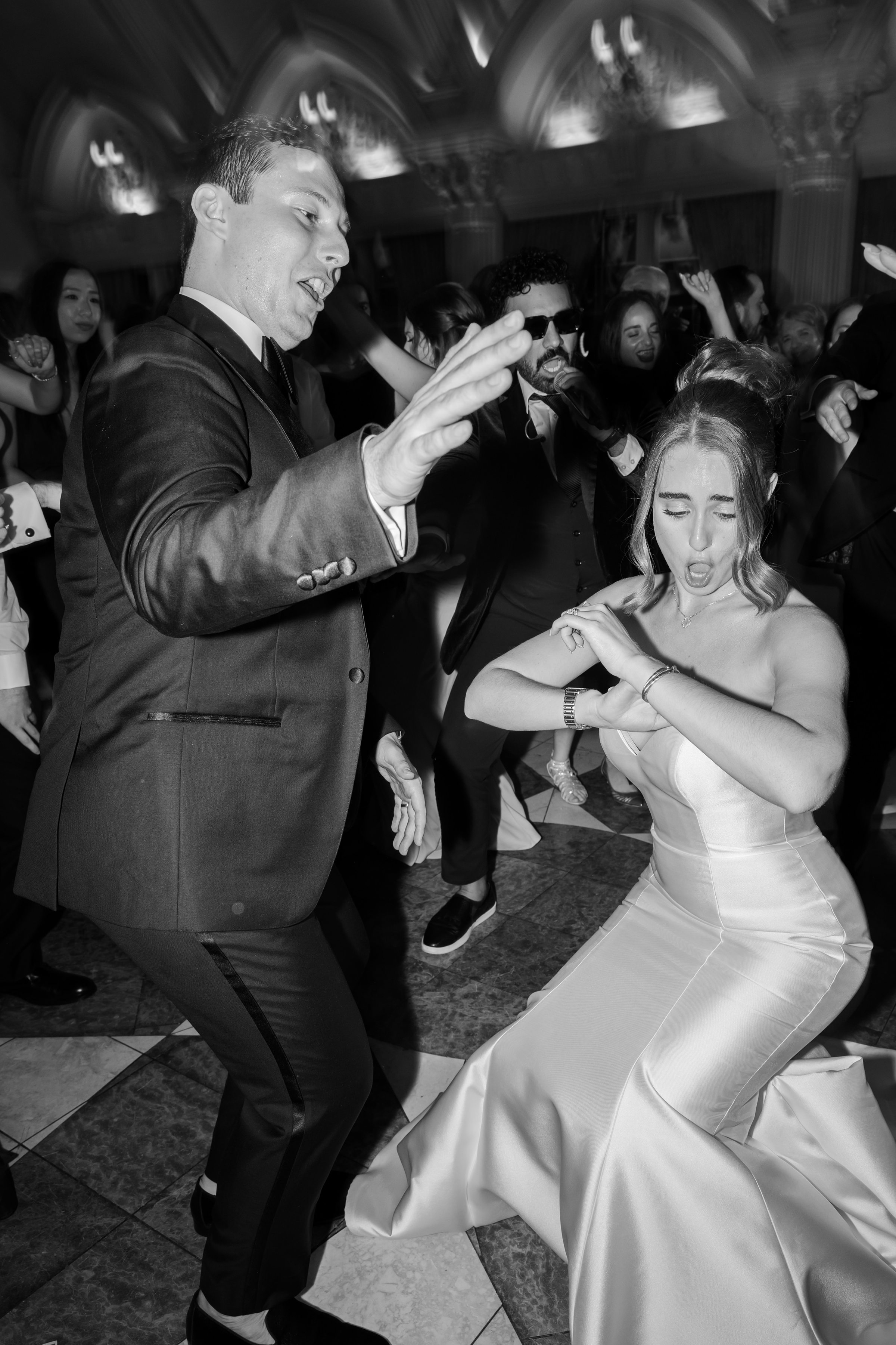 Bride and groom dancing with guests, picture is in black and white