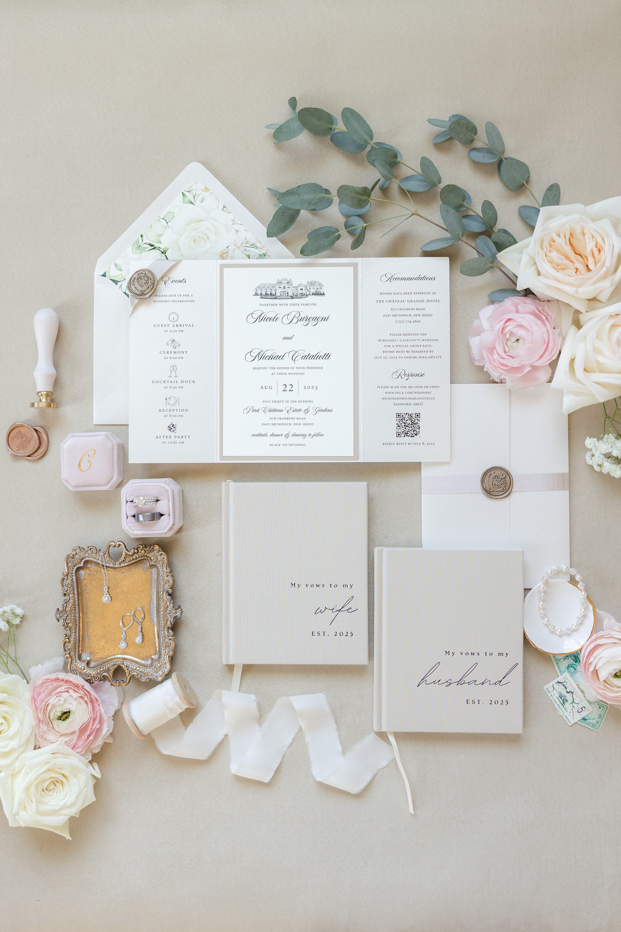 a detail shot of wedding invites, vows, wedding rings, earrings, pearl bracelet with cream, pink flowers