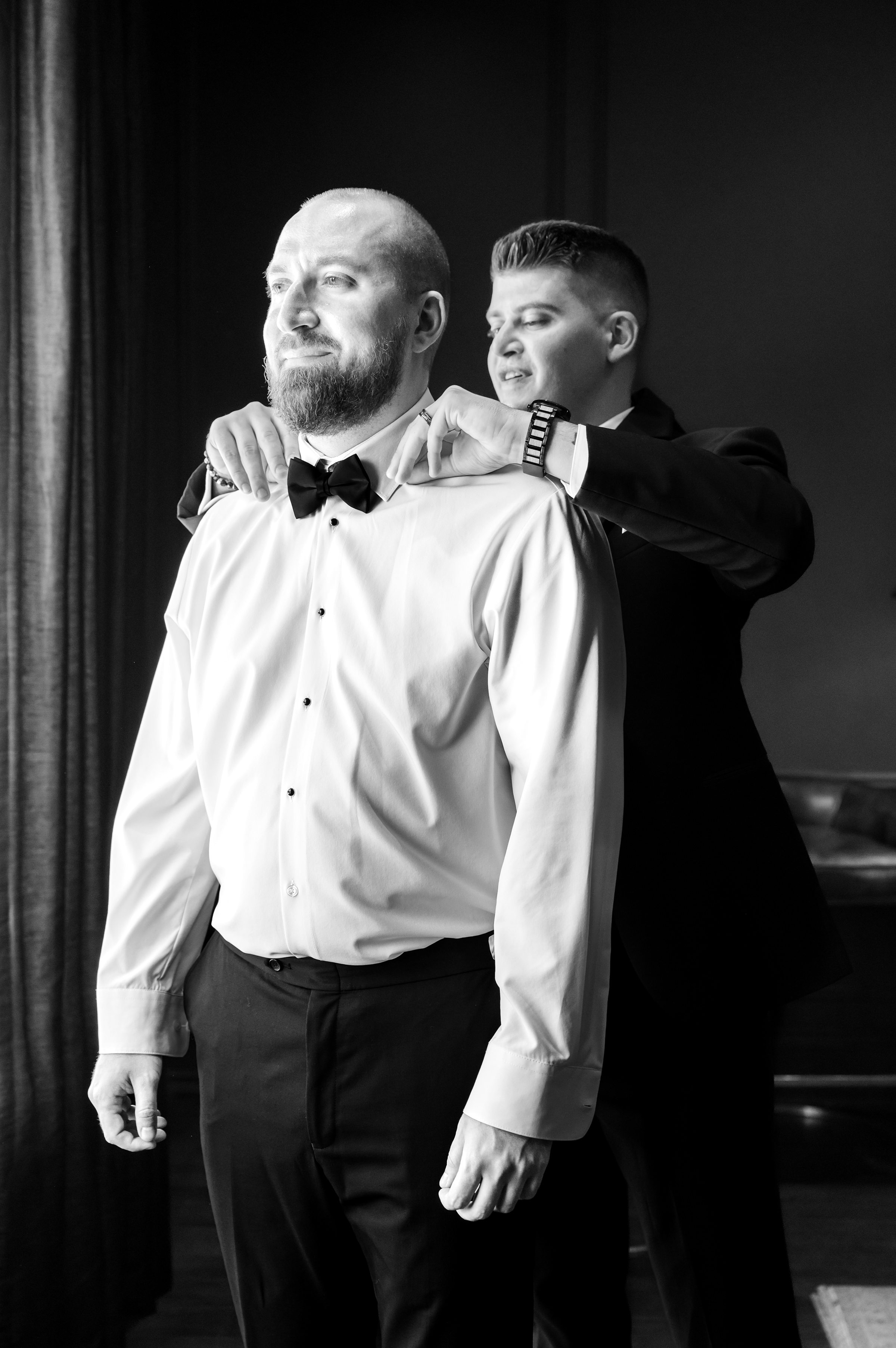 best man helping the groom fix his collar, picture in black and white 