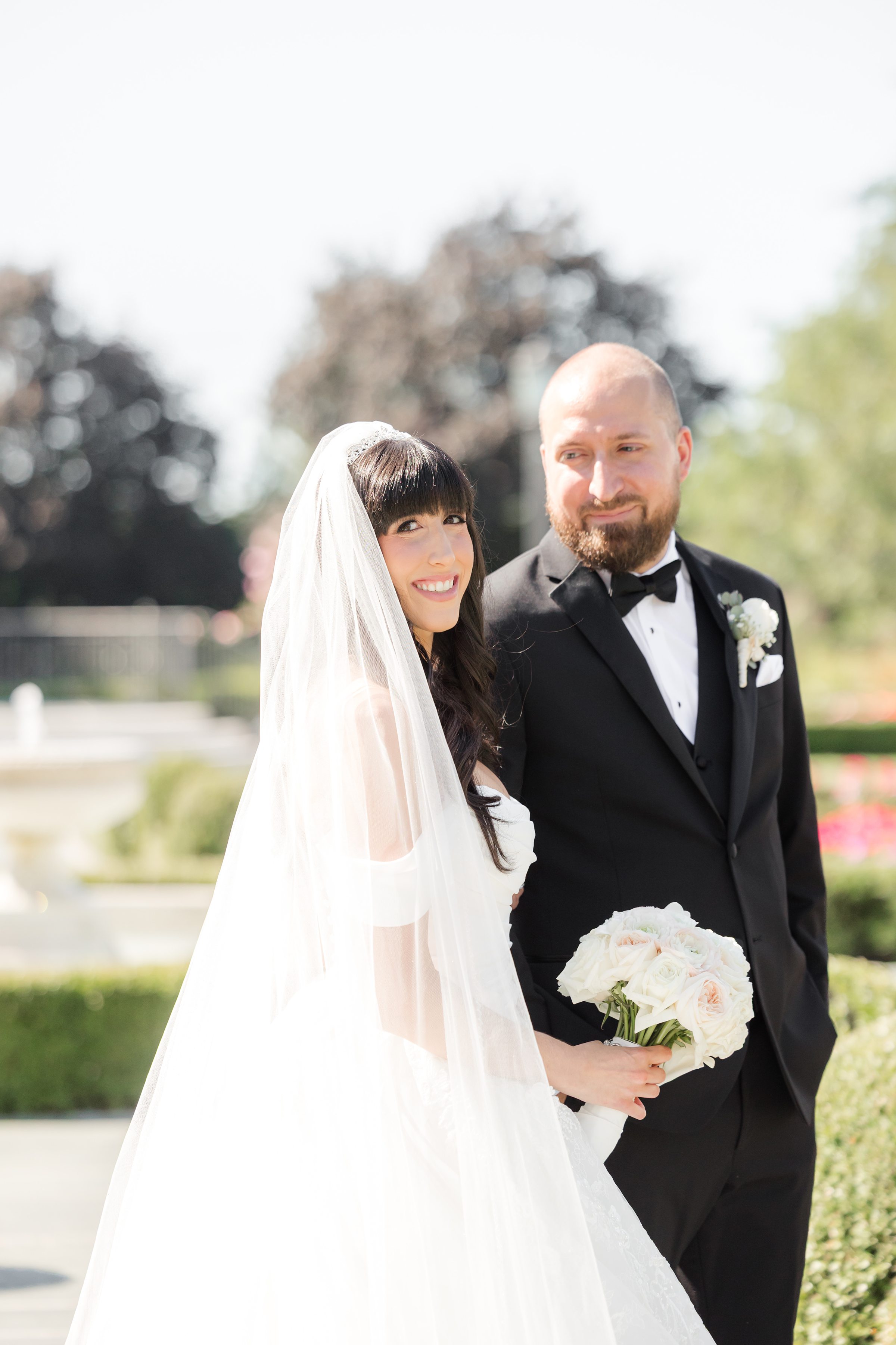 Photo of bride smiling at the camera while groom looking at the bride