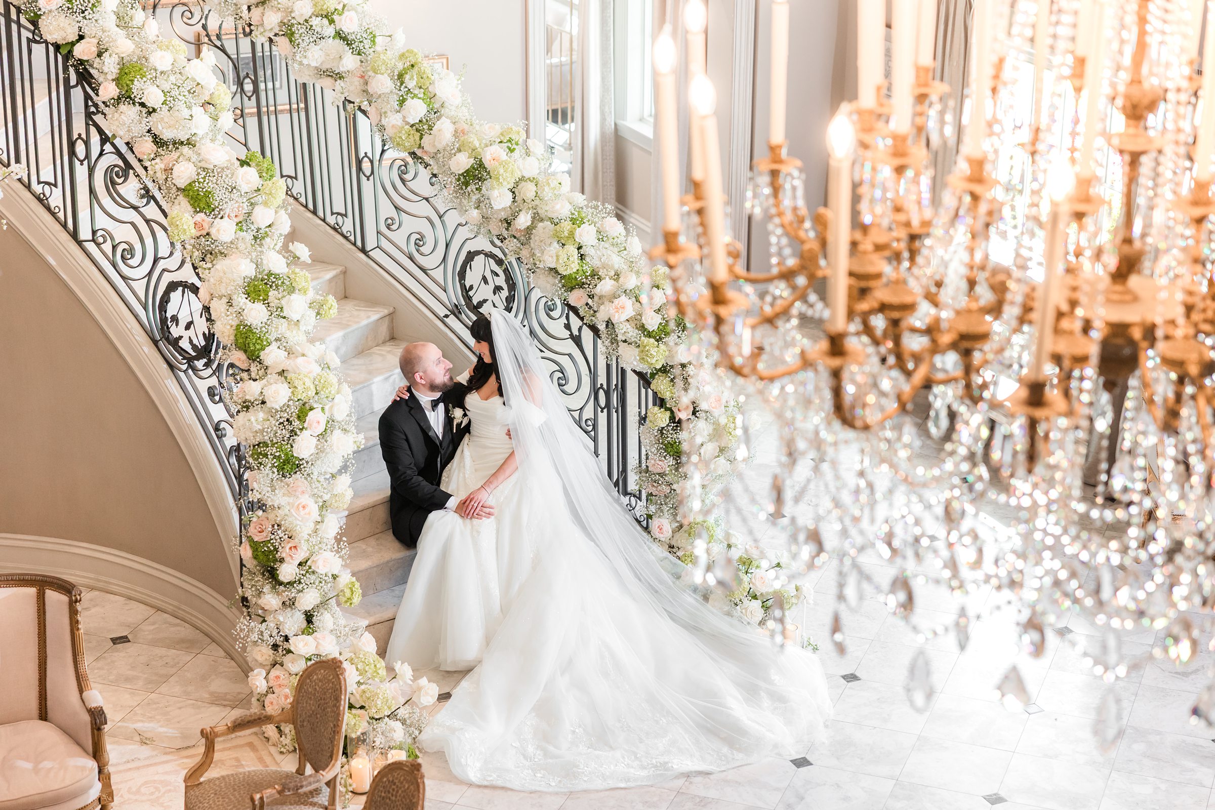 bride sitting on groom's lap at the stairs with flower decorations