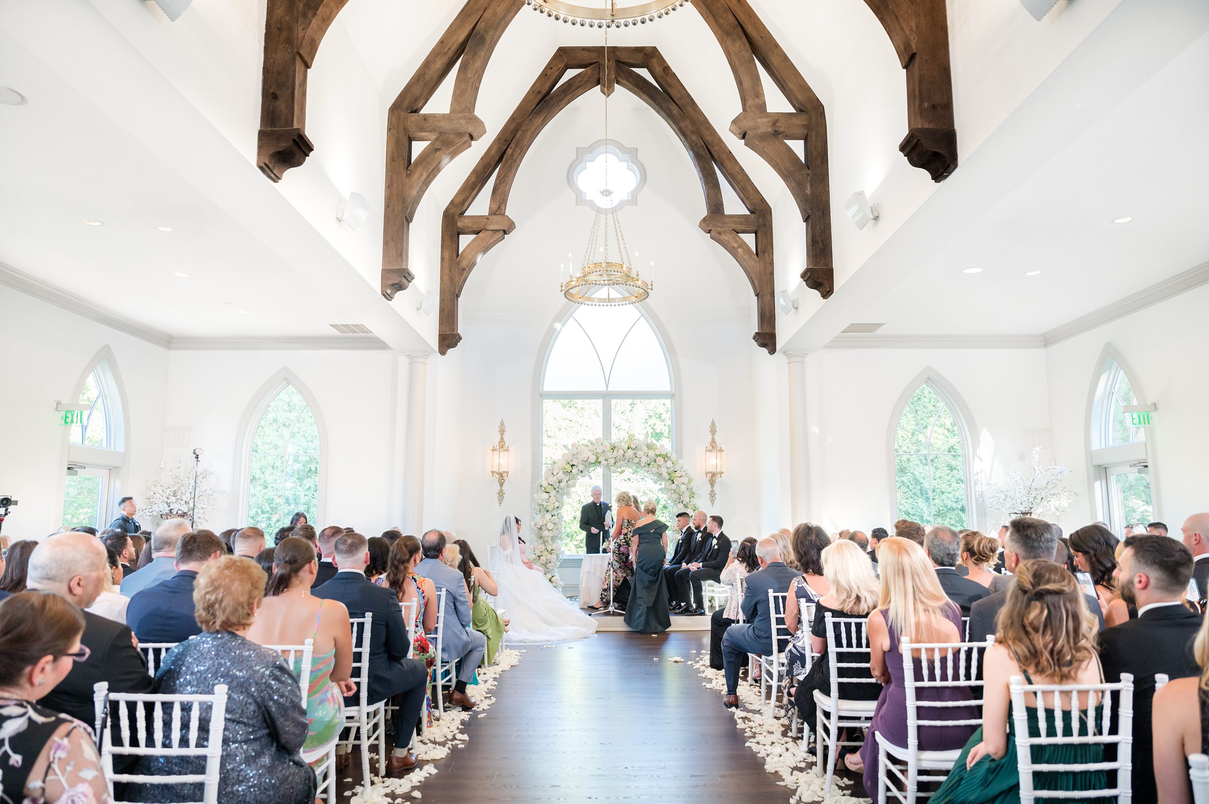 landscape photo of bride and groom at the altar with relatives and wedding officiant 