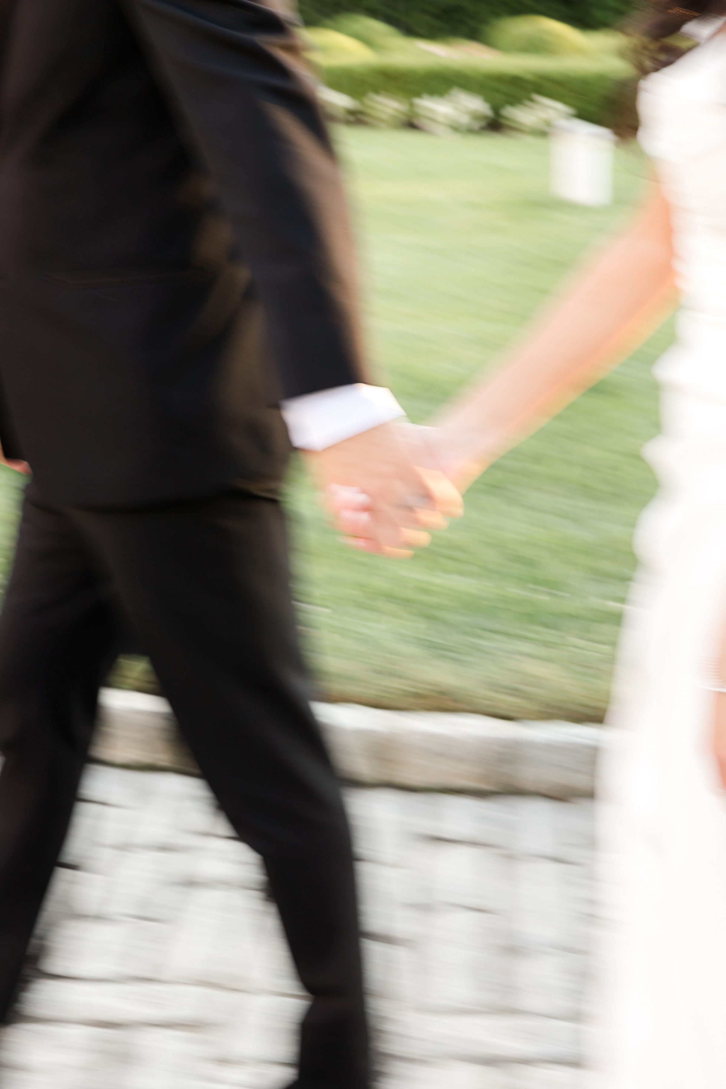Blurred photo of the bride and groom's hands intertwined