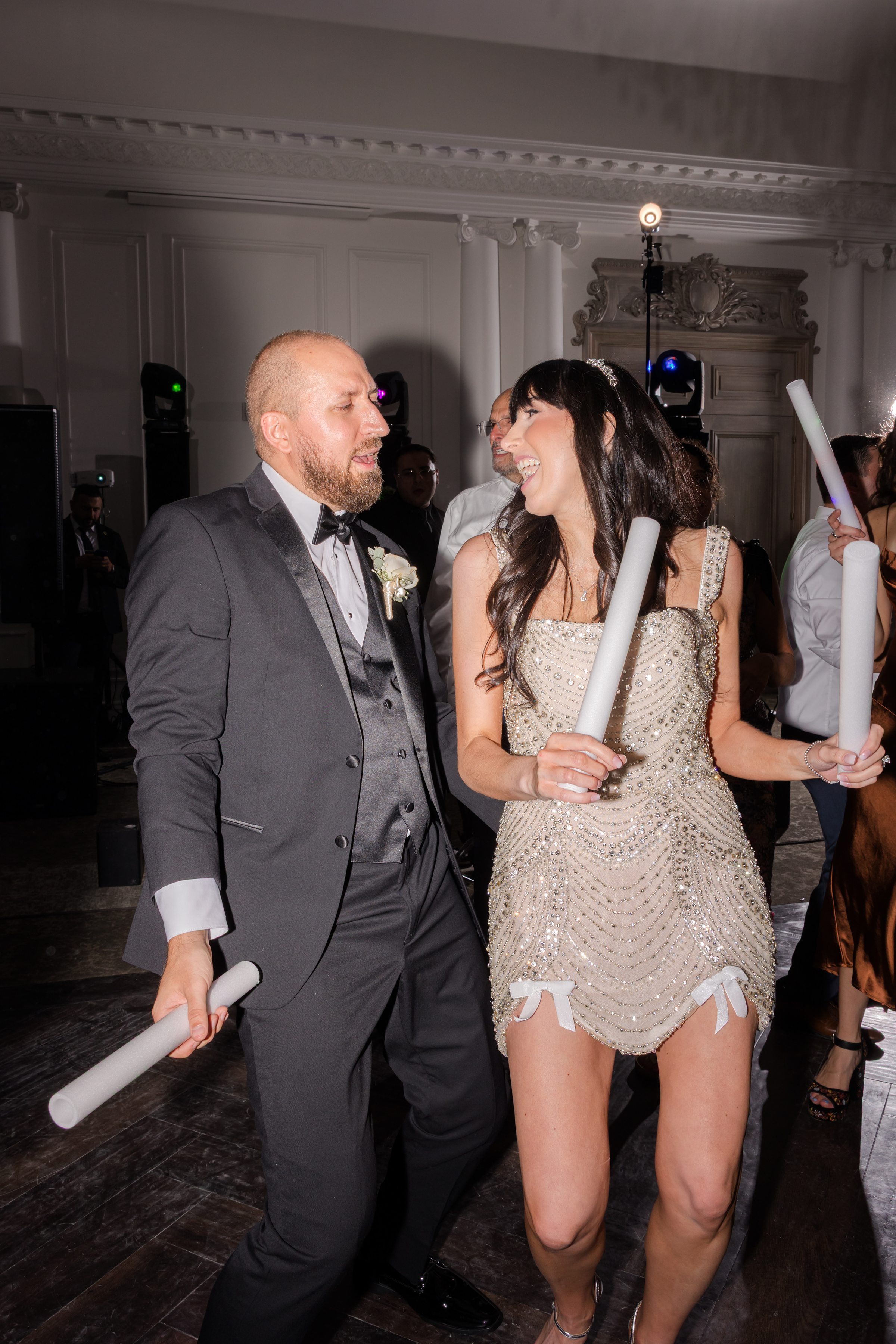 Bride and groom dancing during the after-party, holding lightsticks