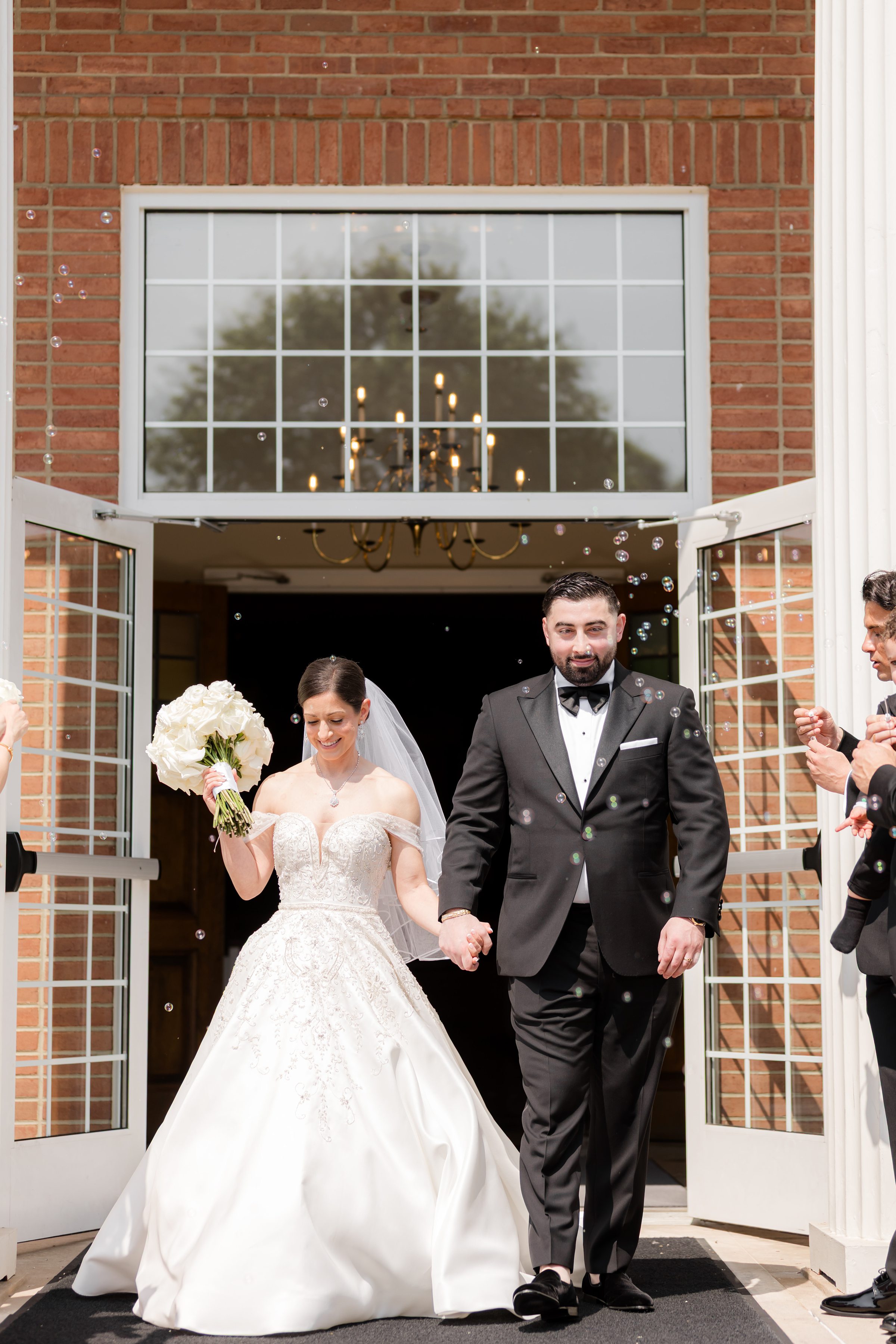 Bride and groom exiting the Church of Nativity with bubbles blown