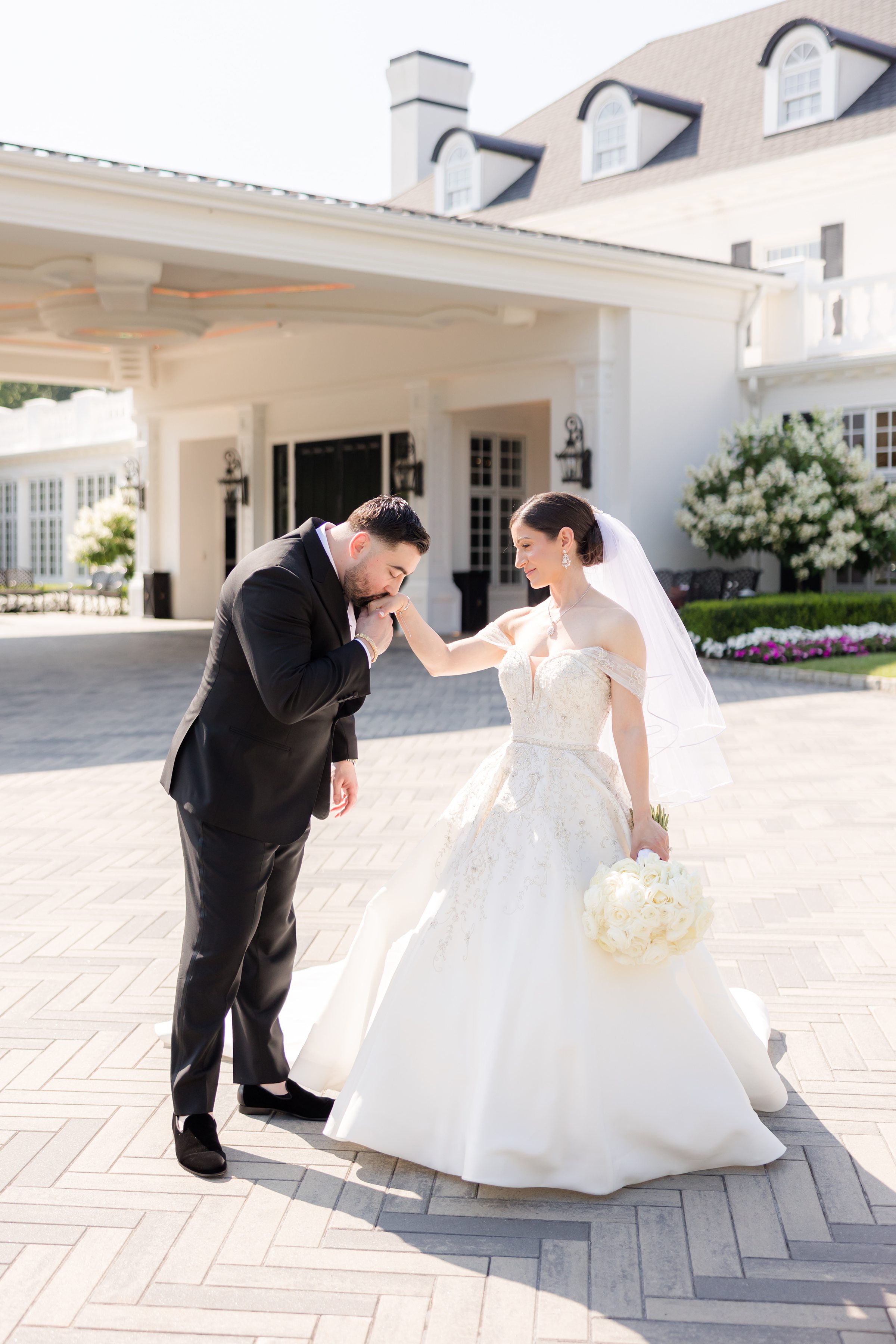 Bride and groom at the entrance of Shadowbrook. Groom is holding the bride's right hand, as she looks at him