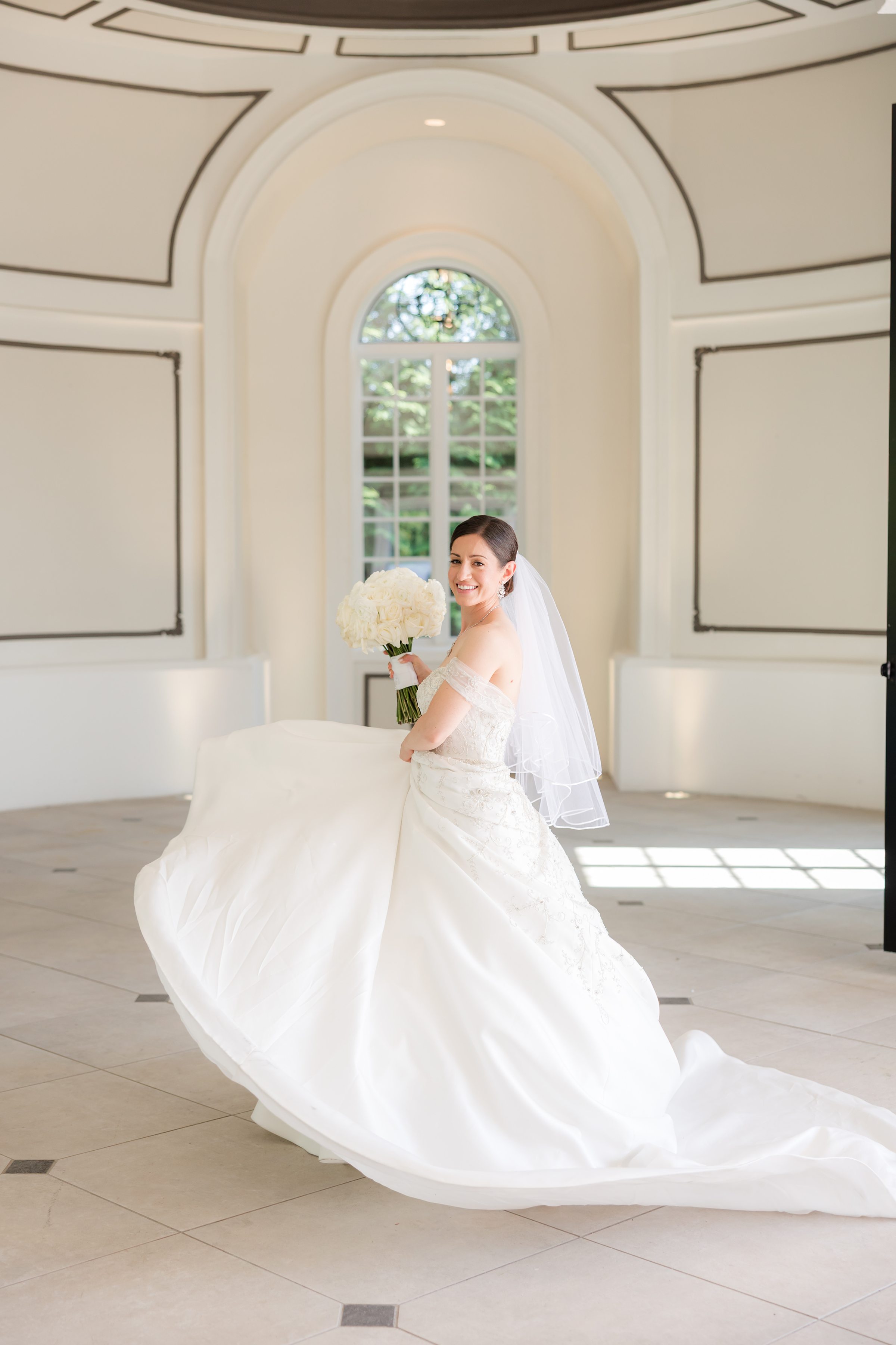 Photo of bride twirling her dress, inside Shadowbrook's chapel