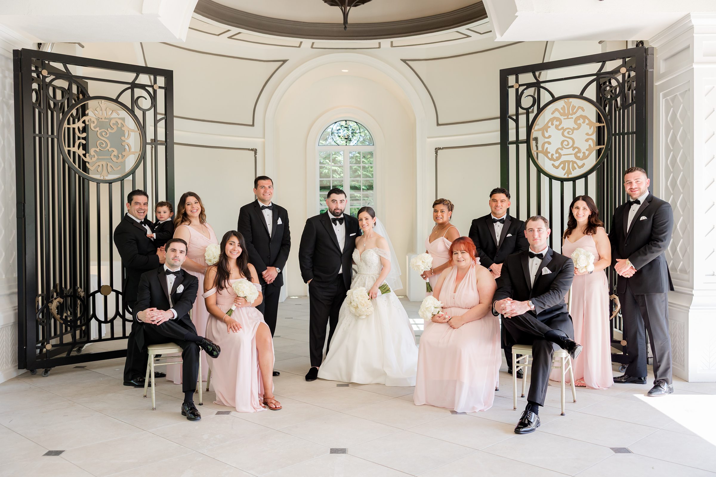 Landscape photo of wedding party with the bride and groom at the center, in Shadowbrook's chapel