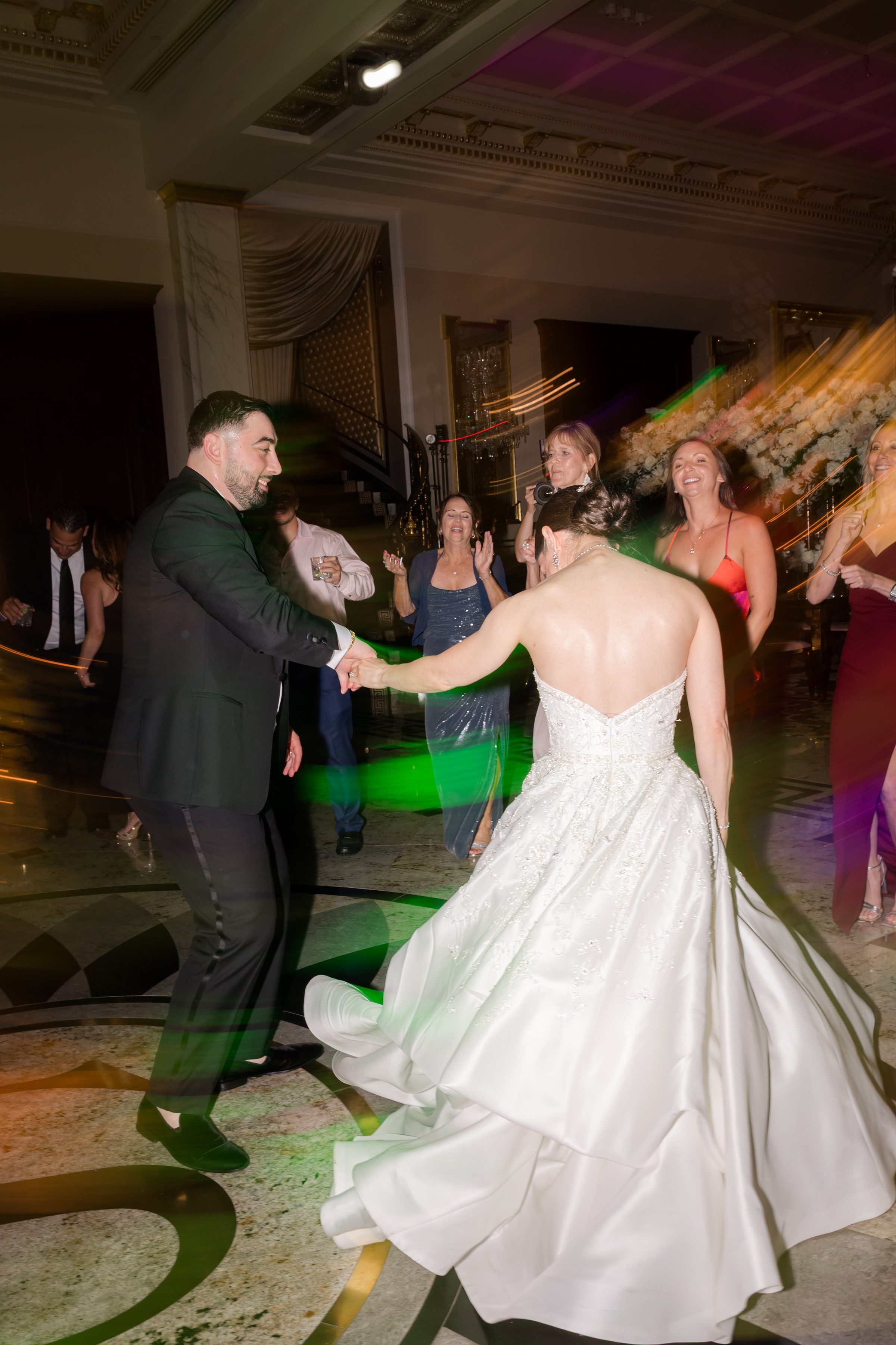 Slightly blurry photo of bride and groom on the dancefloor with spreading lights