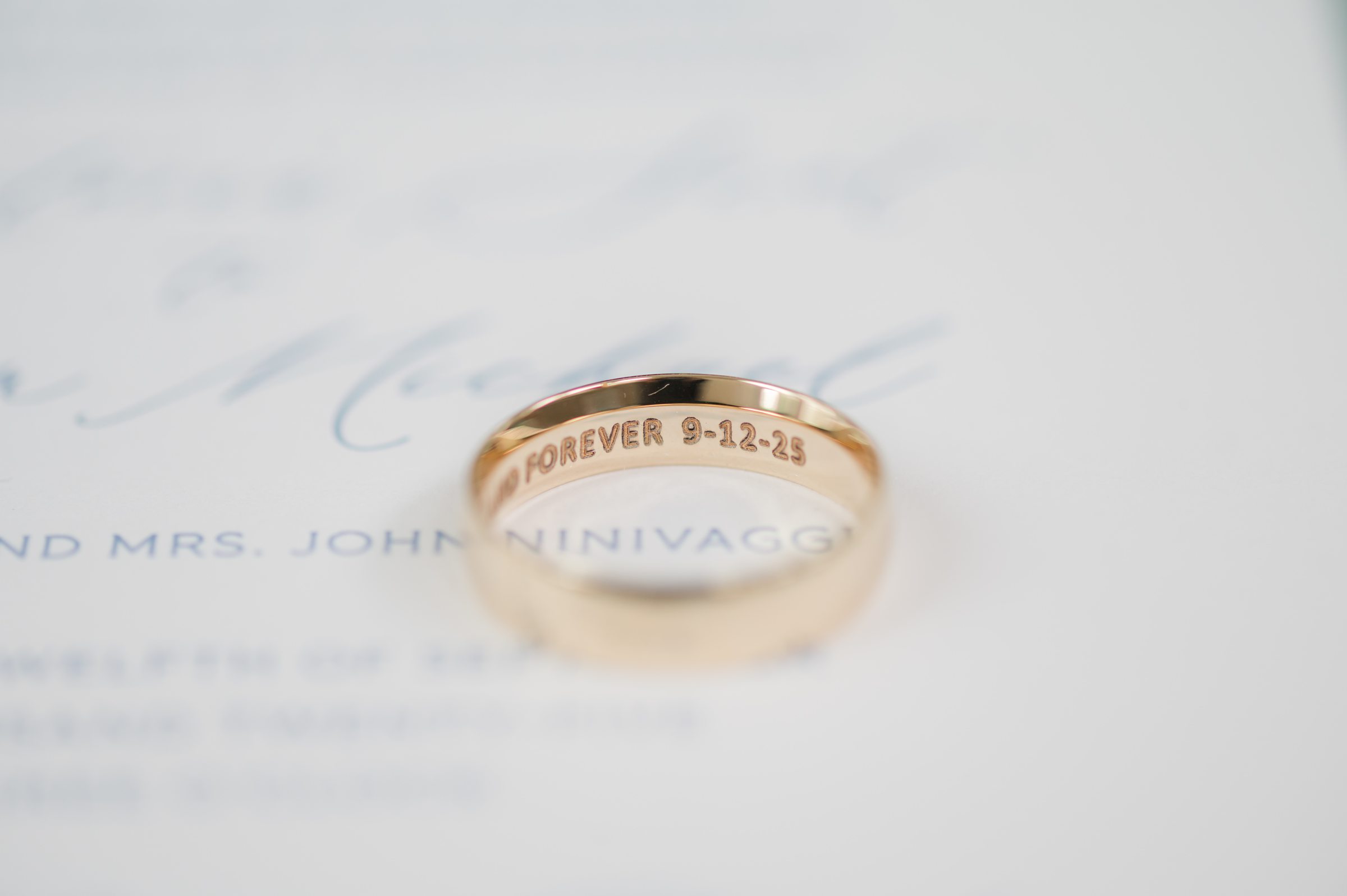 Golden ring engraved with a promise of forever rests quietly, holding a love meant to last a lifetime