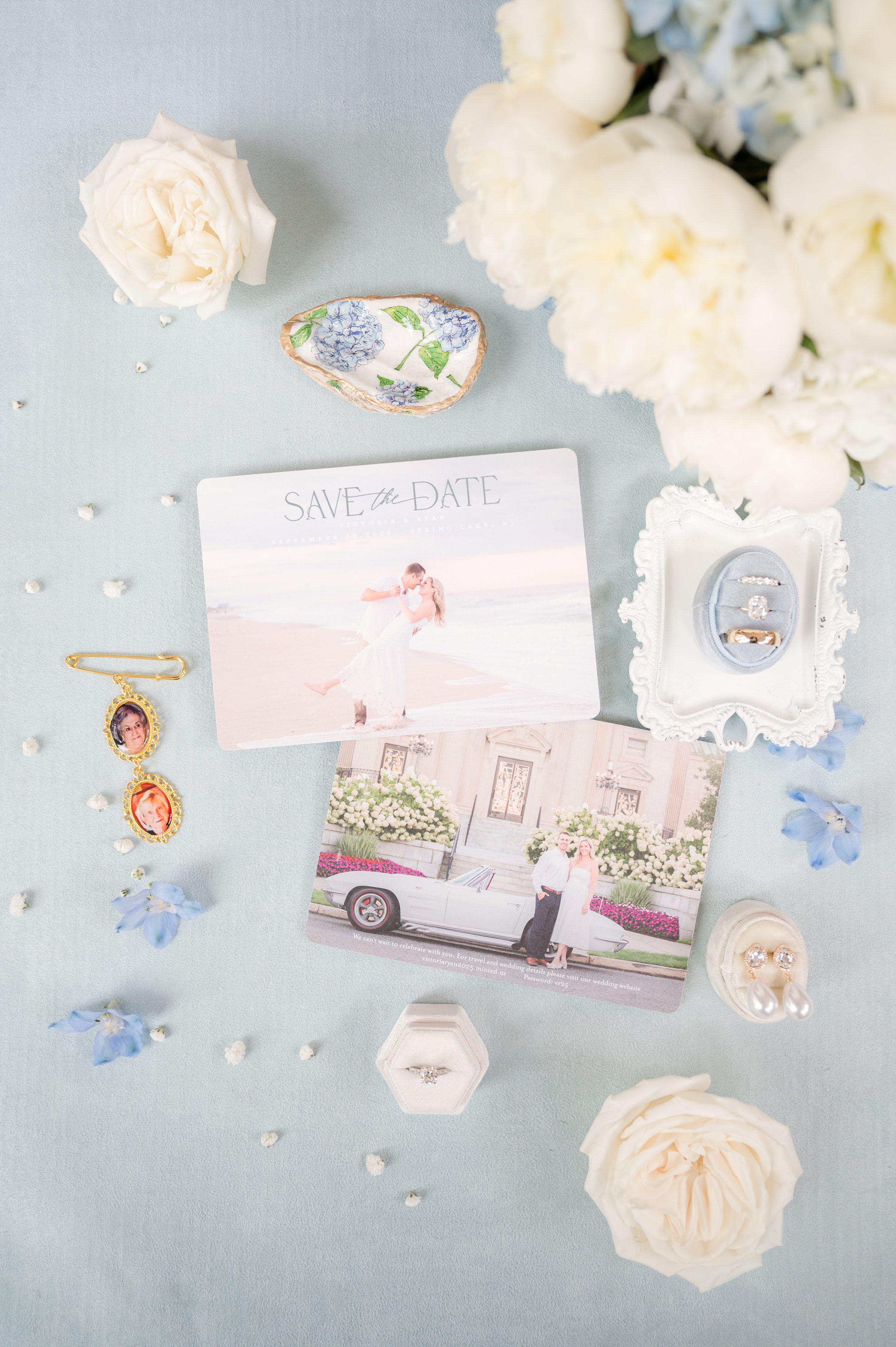 Wedding stationery and heirloom details arranged with soft florals, featuring a save-the-date card, rings, and cherished keepsakes that tell a heartfelt love story