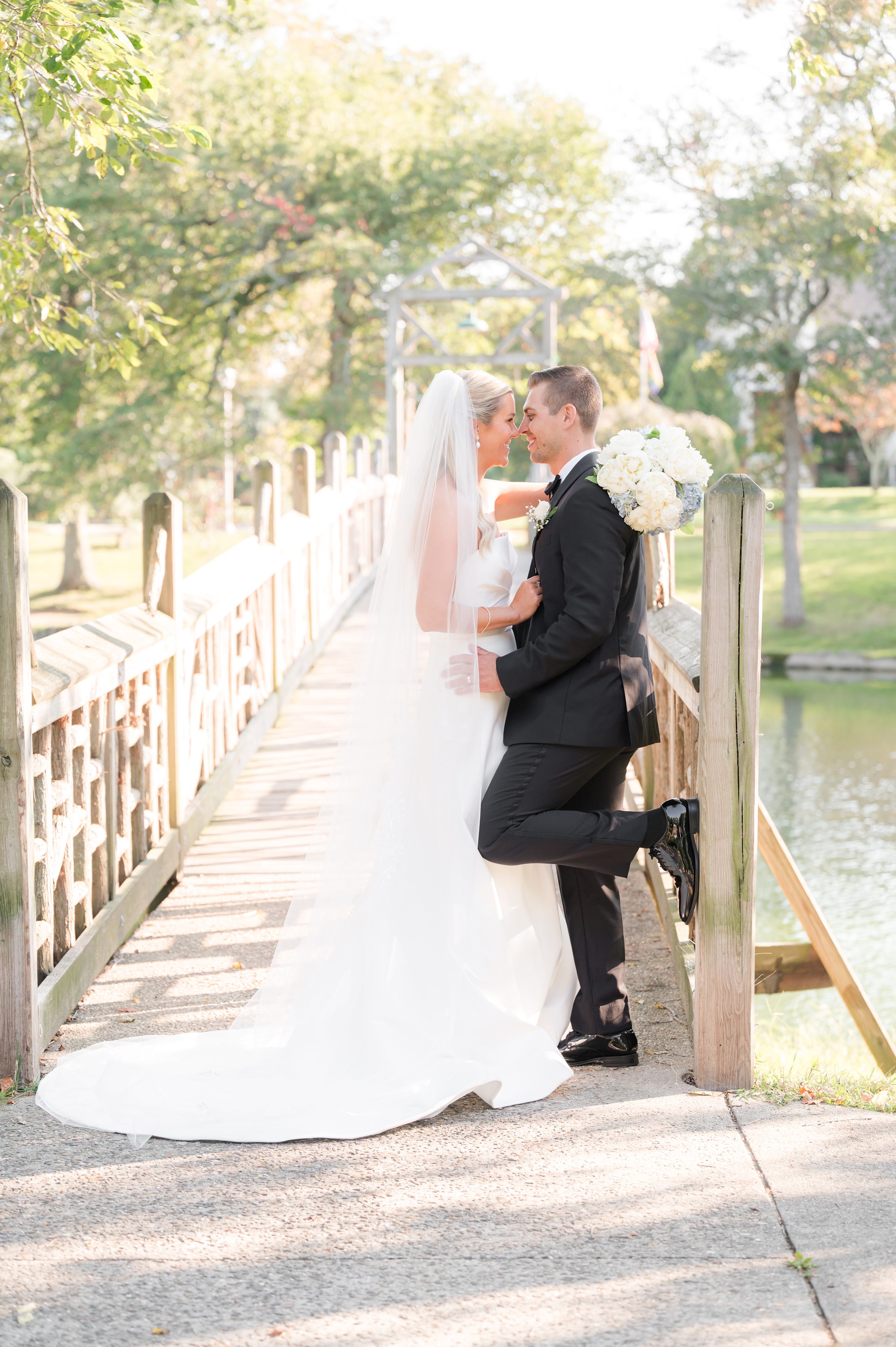 Bride and groom stands close, foreheads nearly touching, sharing an intimate moment filled with love and warmth.