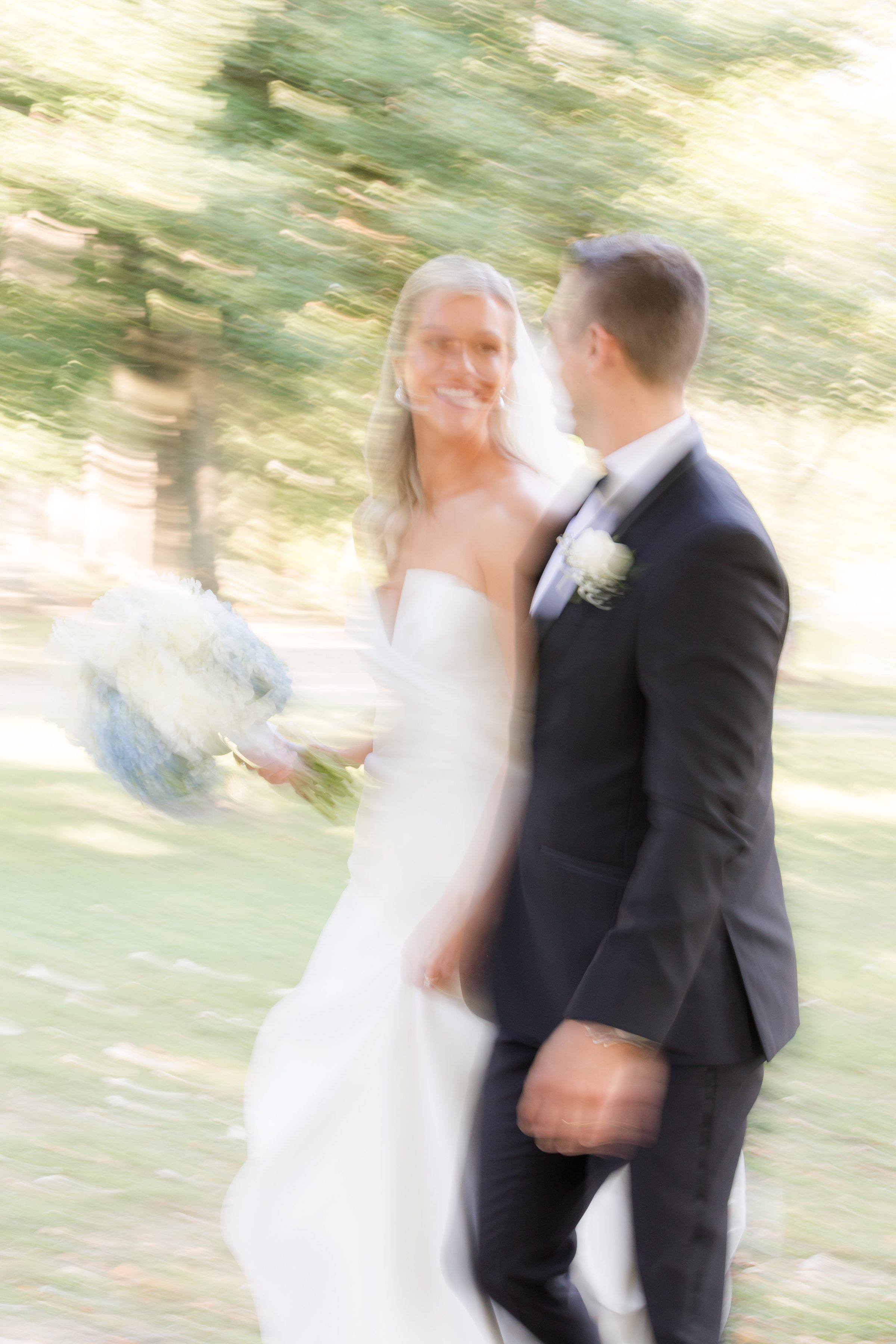 Bride and groom walks together in a dreamy blur of movement, symbolizing the excitement of their new journey.