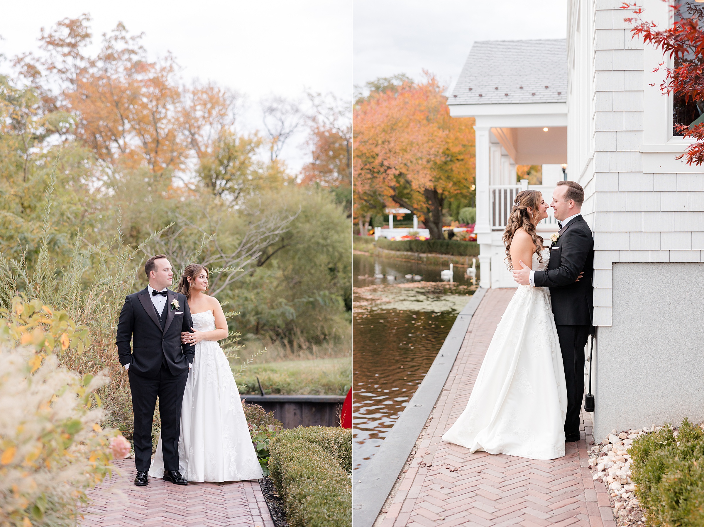 Bride and groom embracing beside a lakeside building with fall foliage reflected in the water.