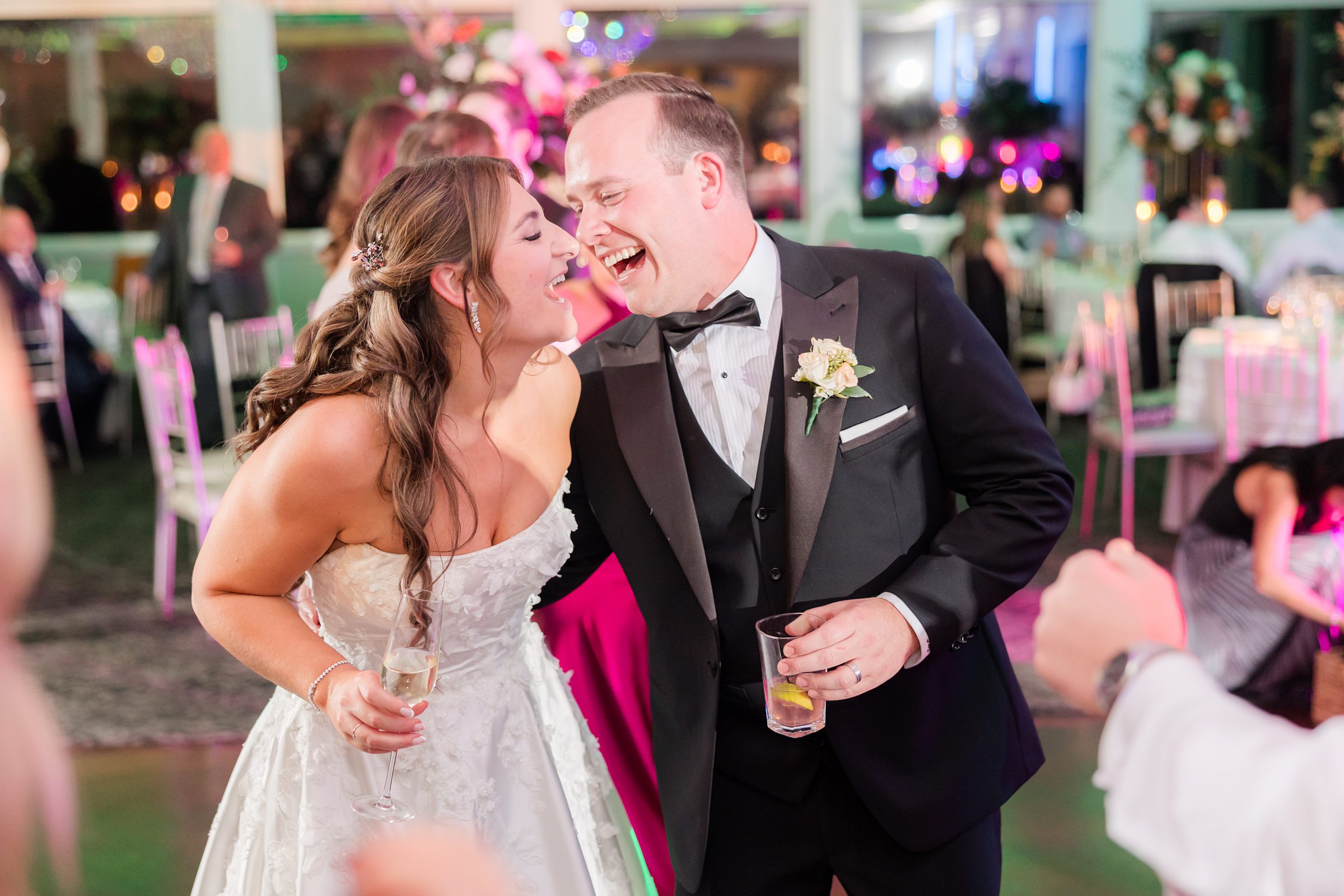 Bride and groom laughing closely together during the reception.