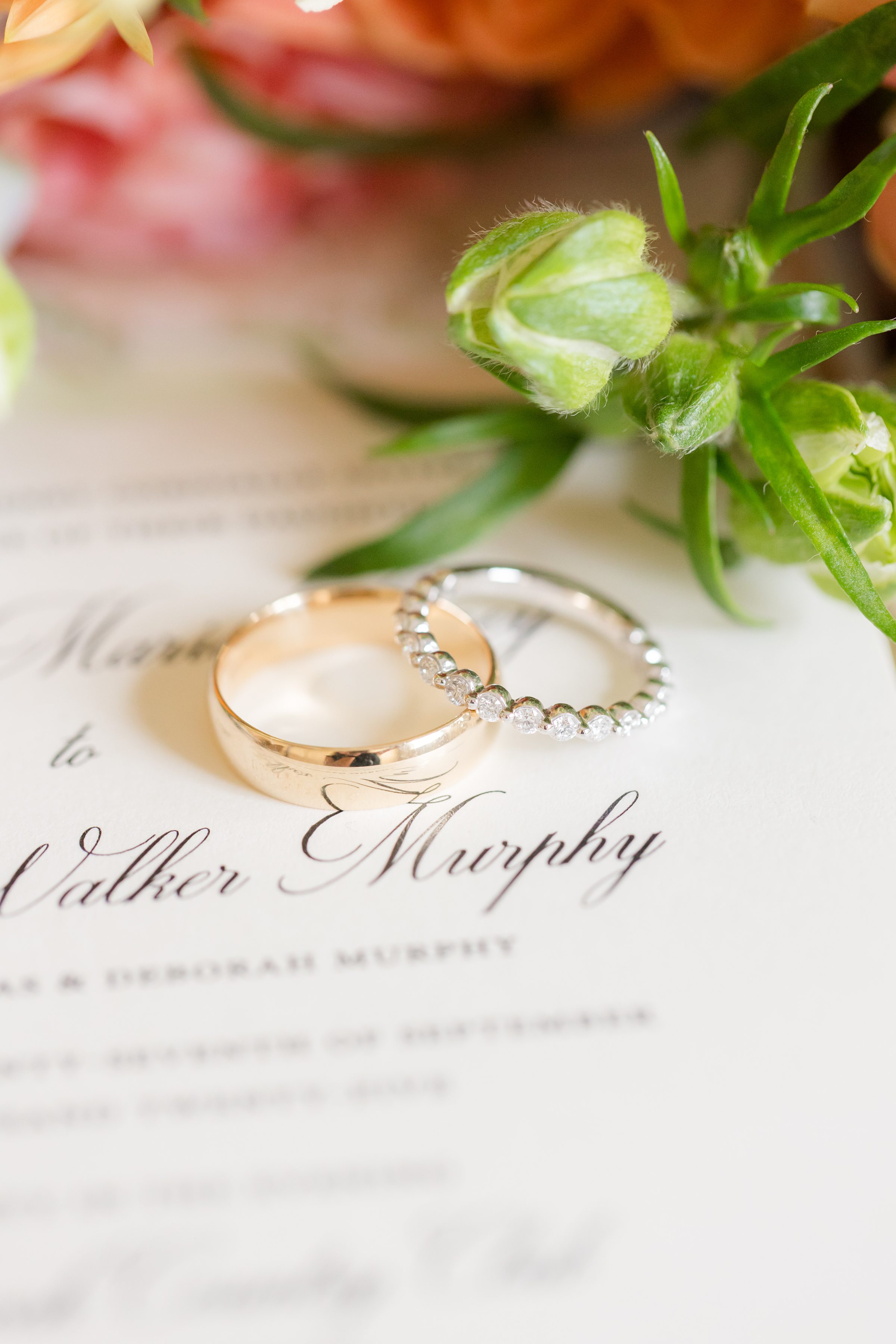 Wedding rings resting on an invitation, symbolizing a promise of forever.