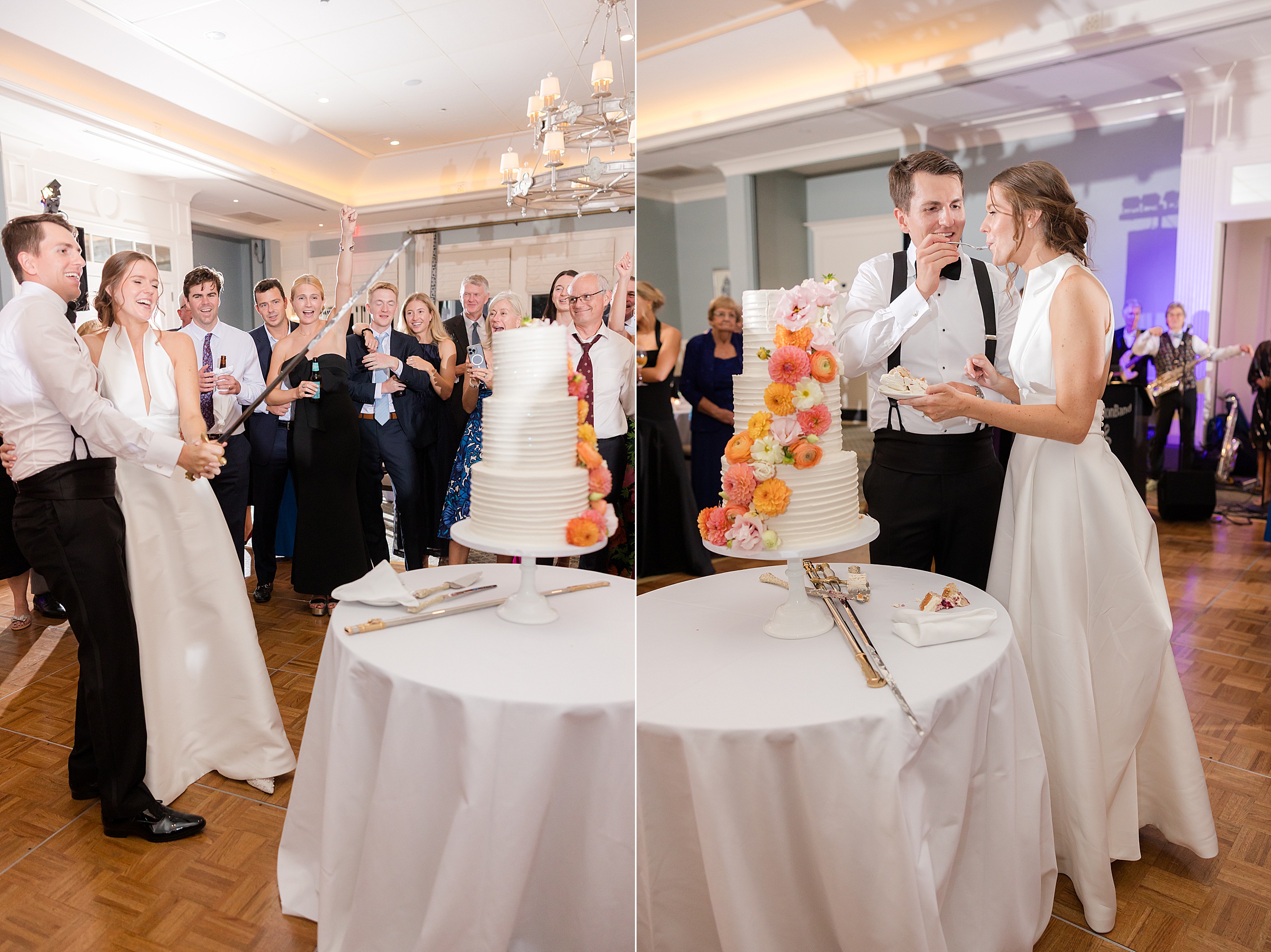 Bride and groom cut their wedding cake with a sword and share a bite together while guests gather and celebrate around them.