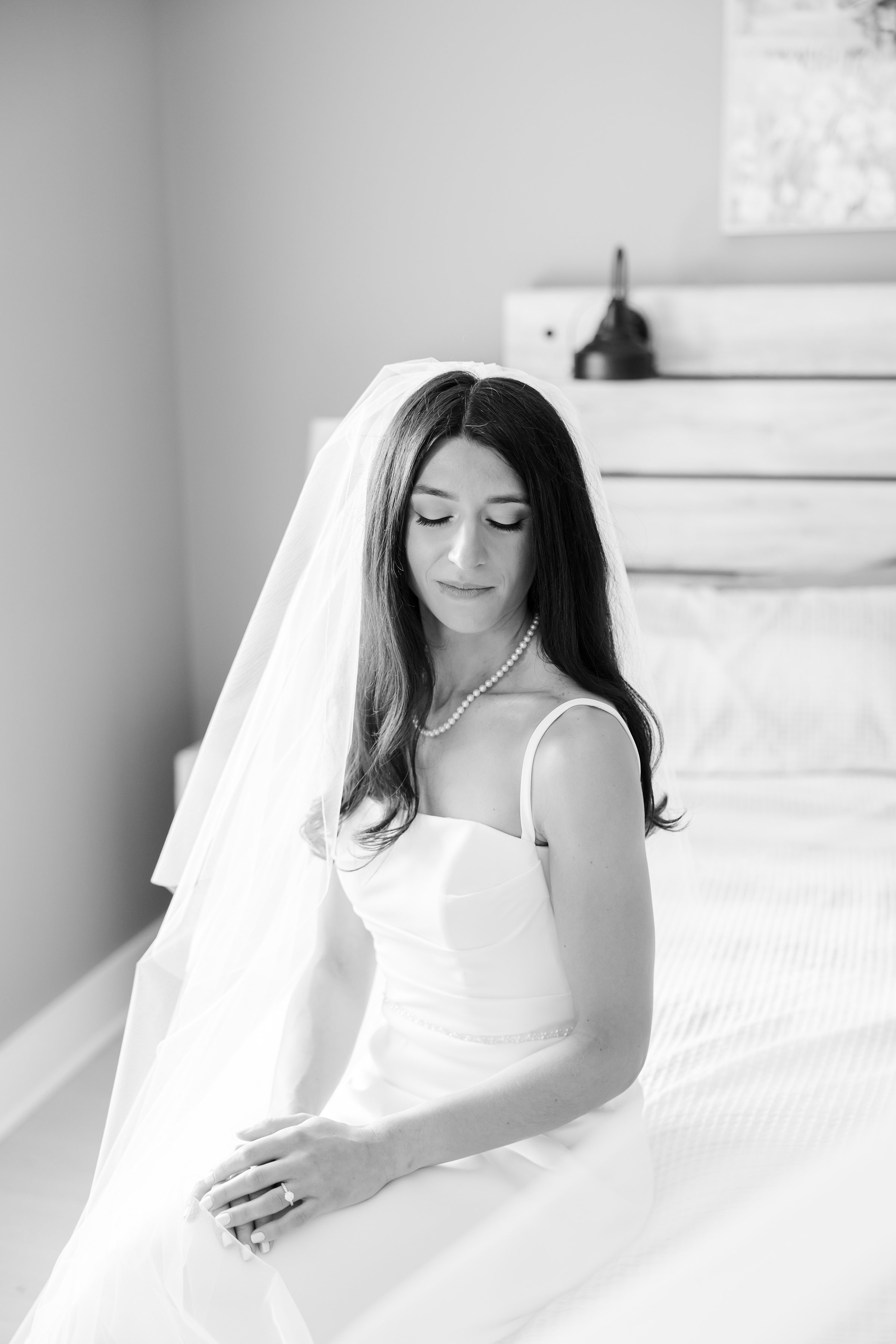 Bride sits quietly, her expression soft and reflective, savoring the stillness before stepping into a new chapter of love.