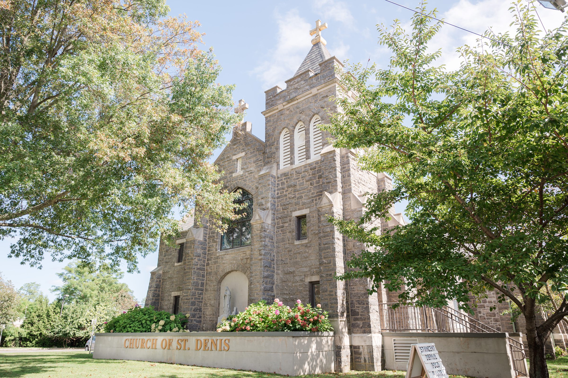 A timeless stone church stands beneath a bright sky, its doors ready to welcome a celebration of love and lifelong commitment.