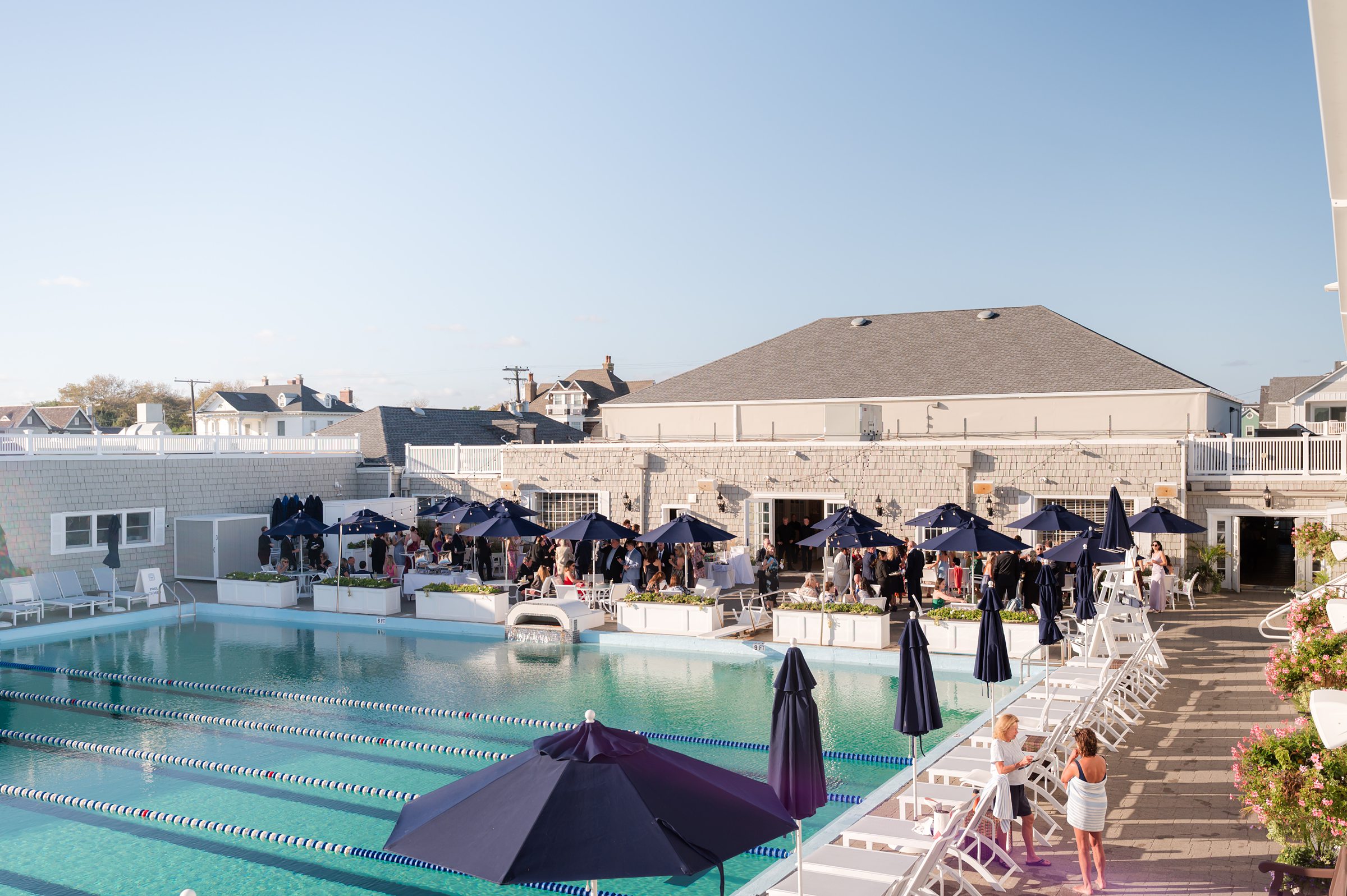 Guests gather outdoors under soft sunlight, mingling and celebrating as the joyful energy of the wedding day fills the air