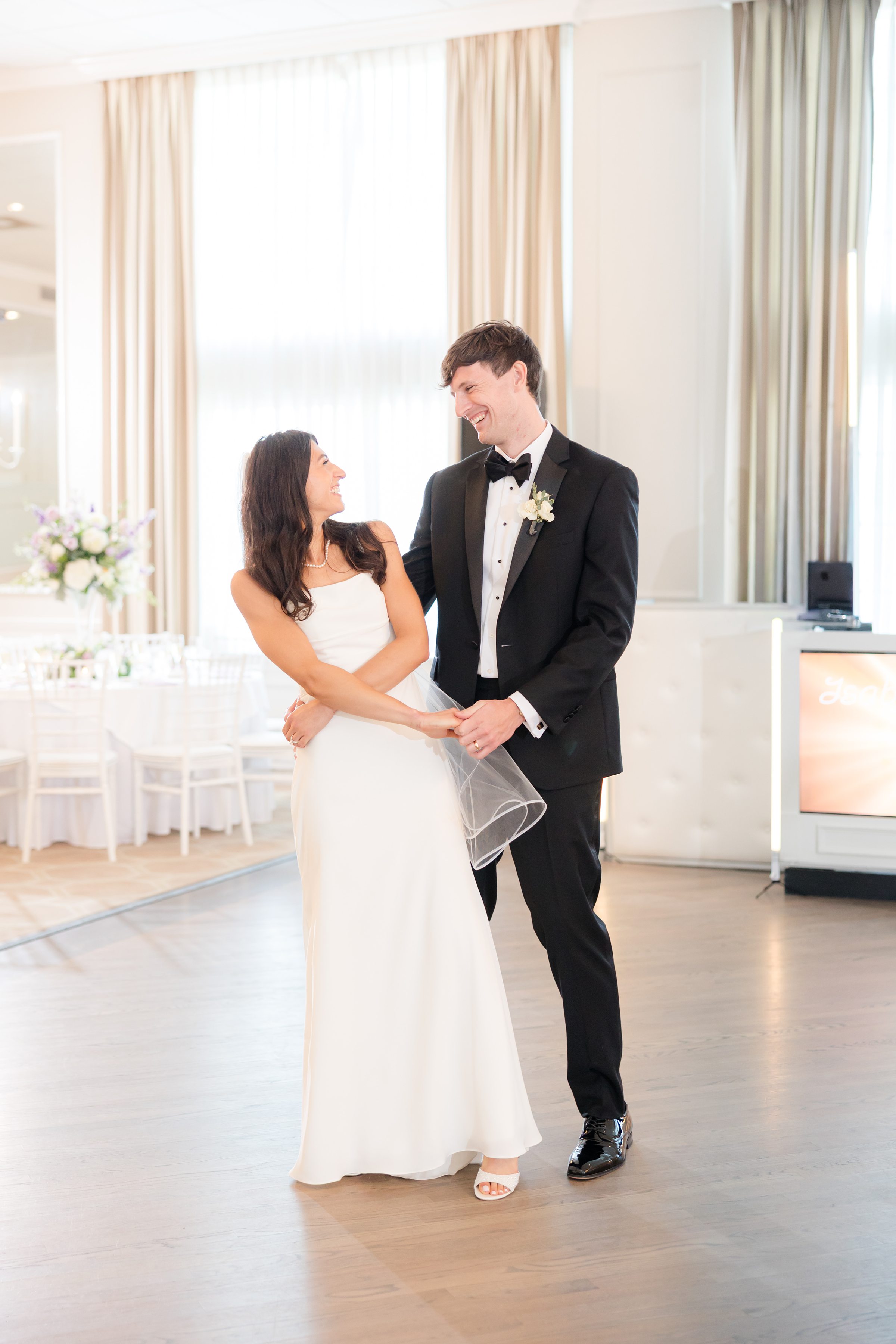 Bride and groom shares a tender first dance, gazing into each other’s eyes with soft smiles, completely wrapped up in the joy of the moment.