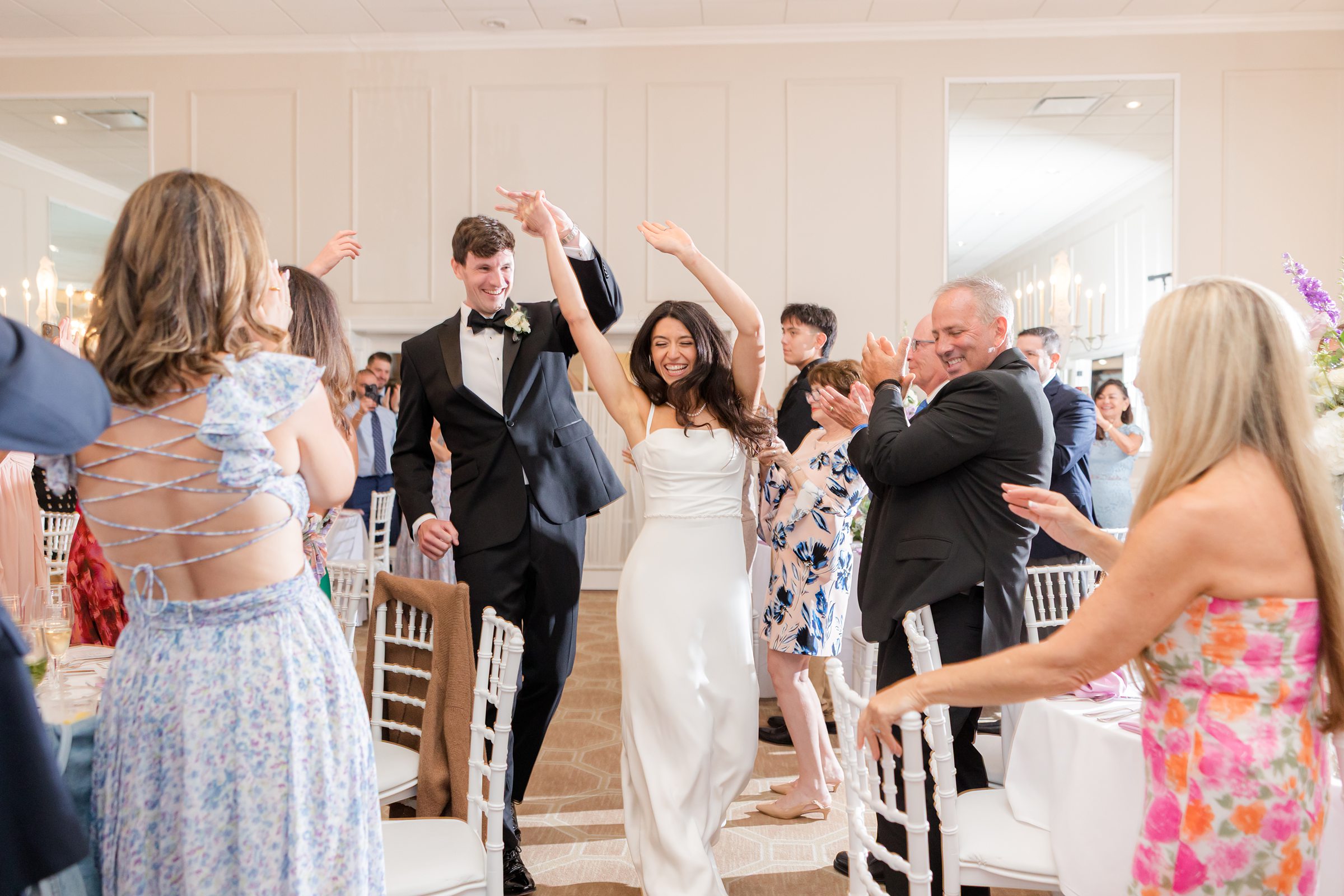 Groom twirls his bride across the dance floor, her dress flowing as they share a joyful, carefree moment together.