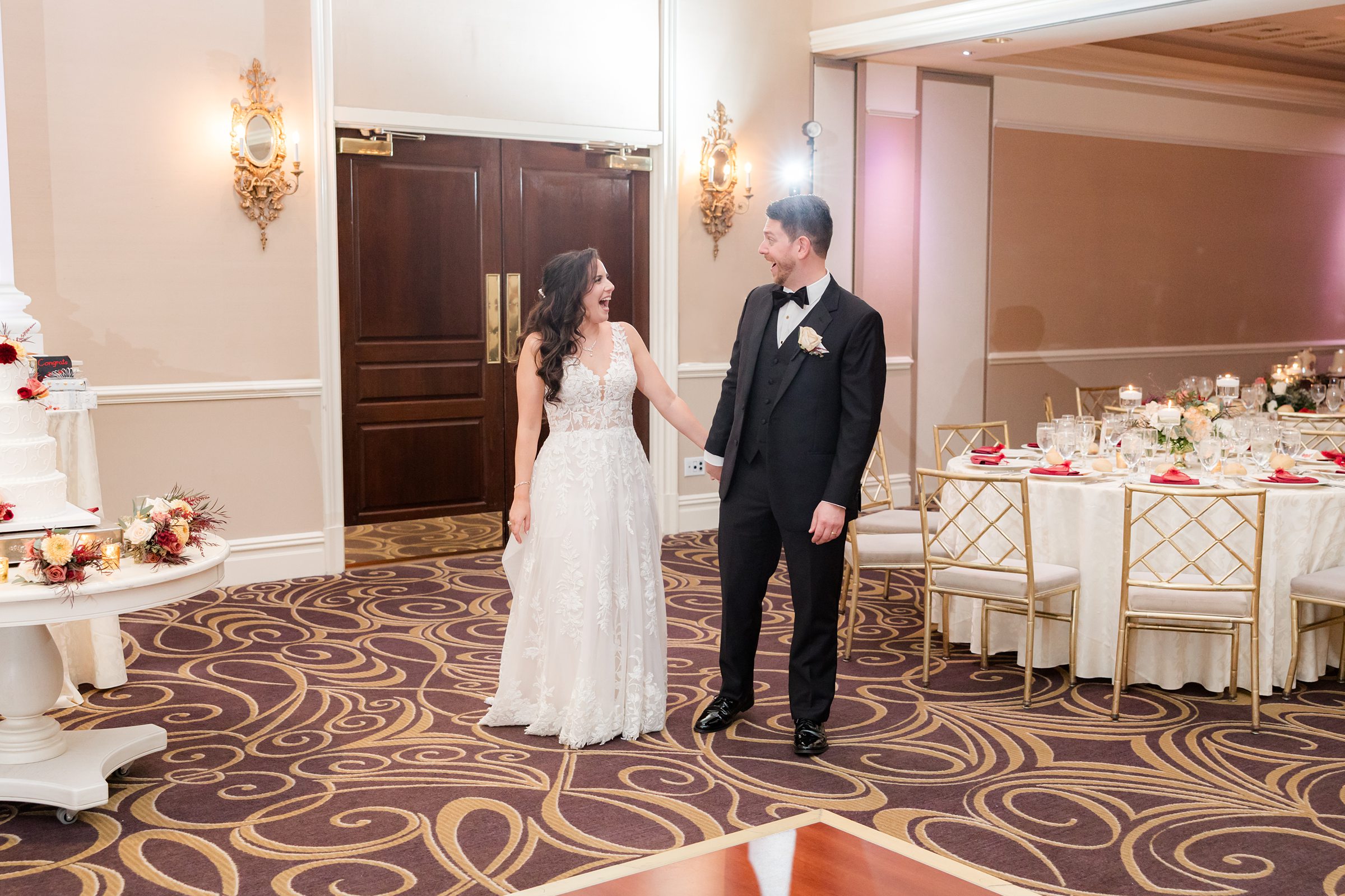Bride and groom smile at each other as they walk into their reception, sharing a joyful and intimate moment together