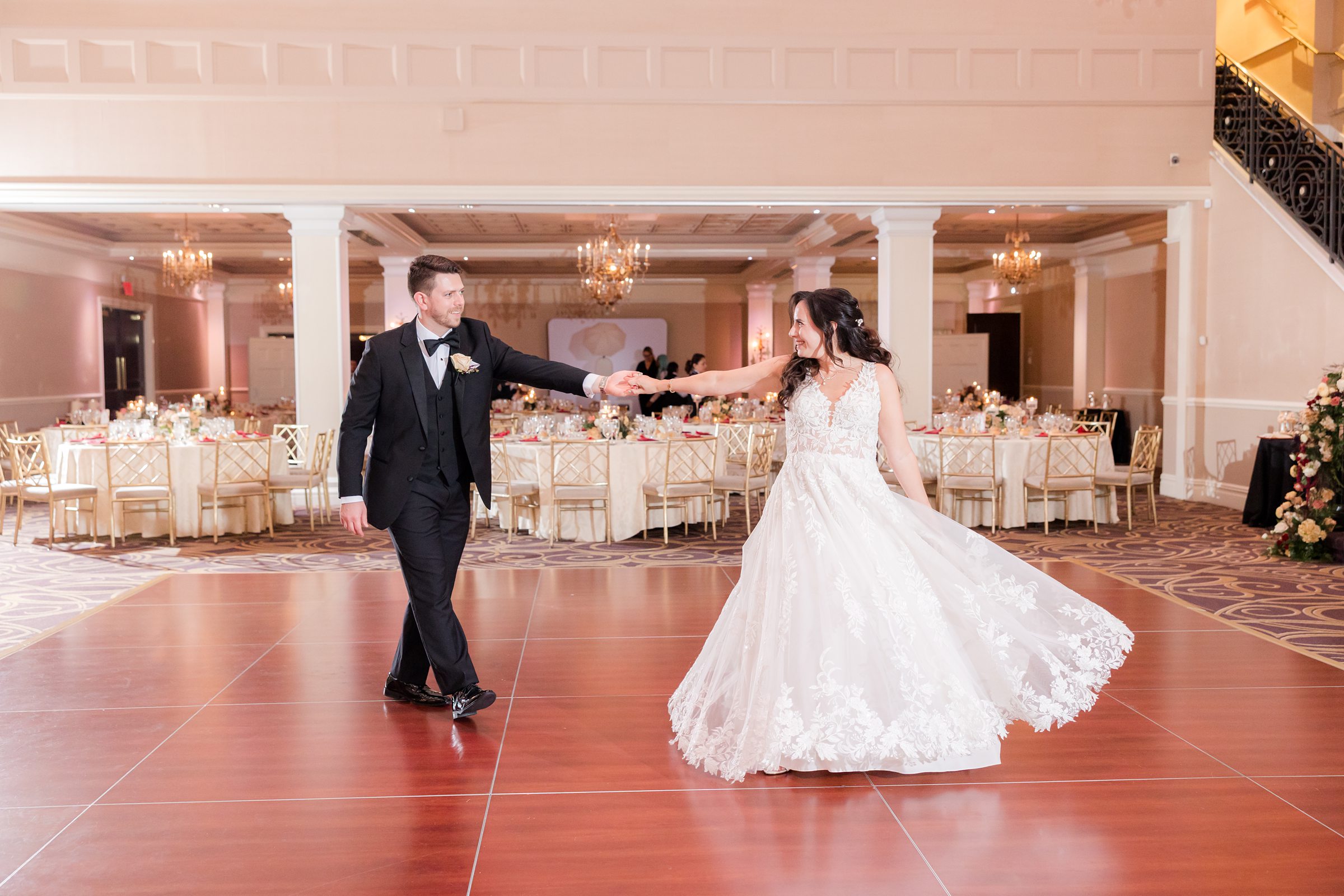 Bride twirls gracefully as the groom holds her hand, sharing a playful and romantic dance together