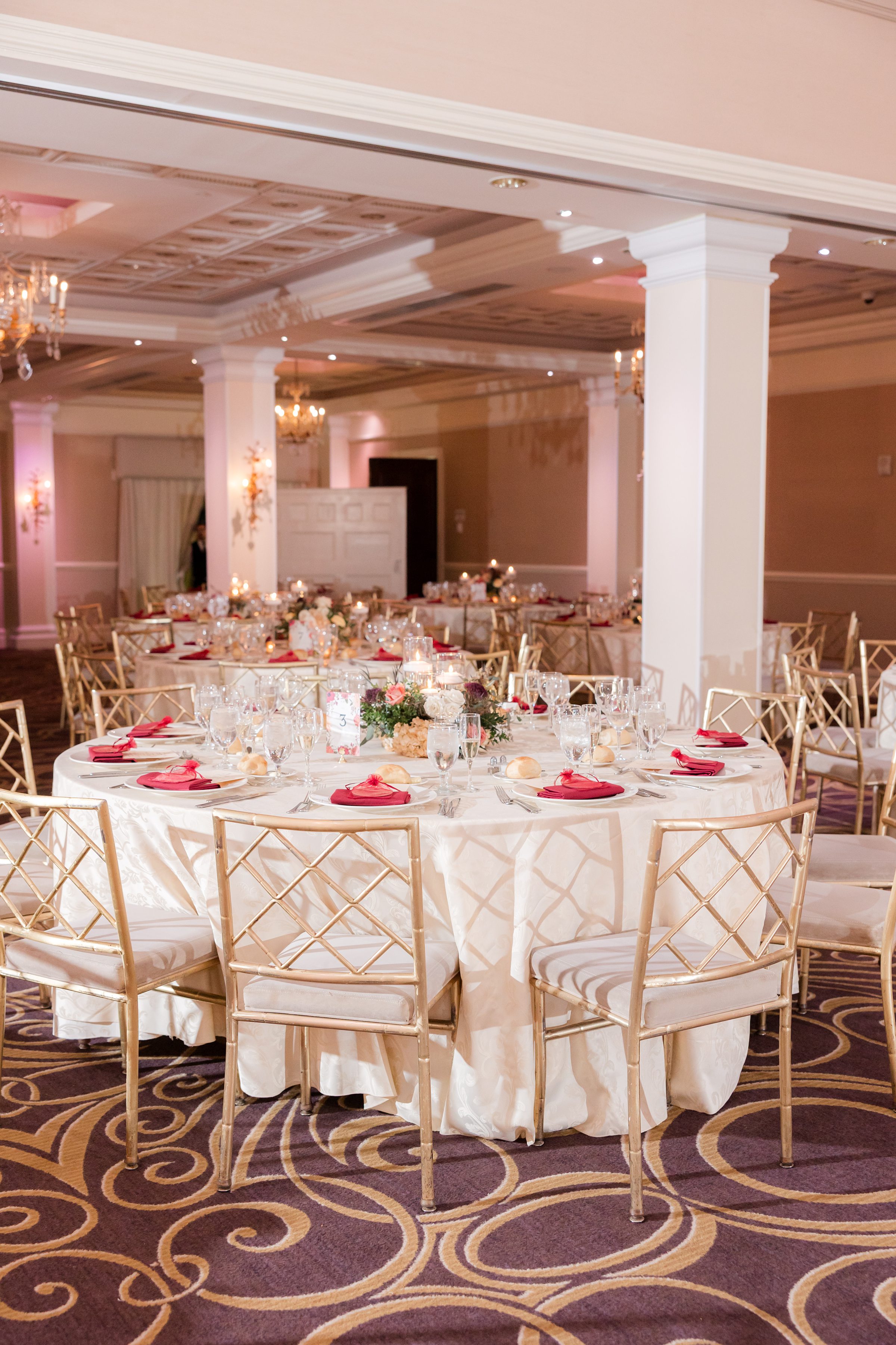 Elegantly set tables glow with candlelight and soft florals, creating a romantic atmosphere for the celebration