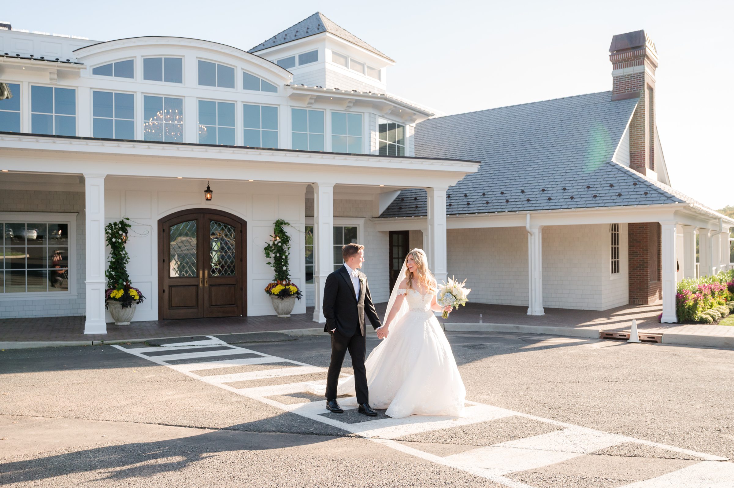 Bride and groom walking together outside their venue, sharing a quiet, happy moment together.