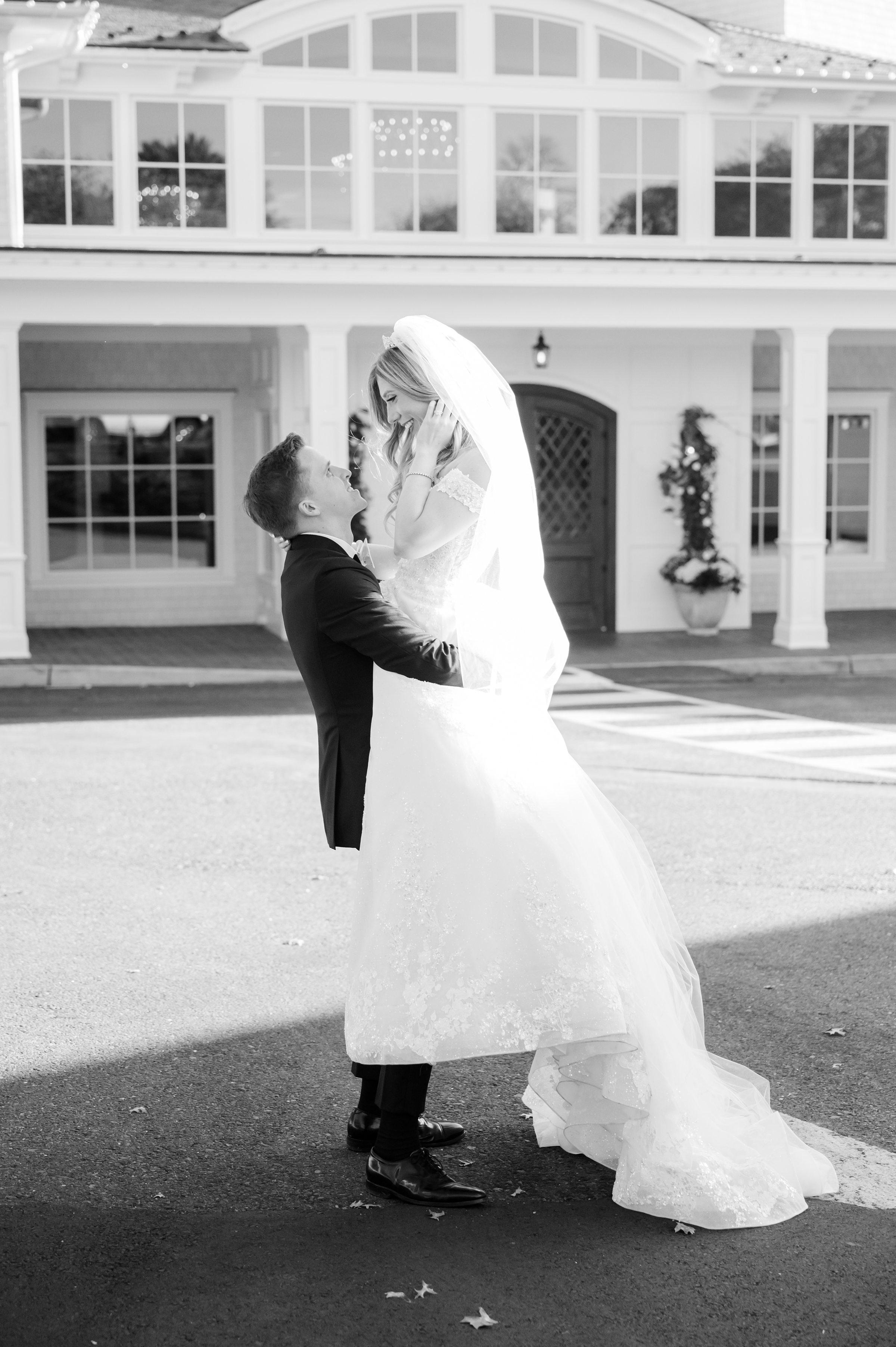 Groom lifting the bride in a joyful, romantic embrace.