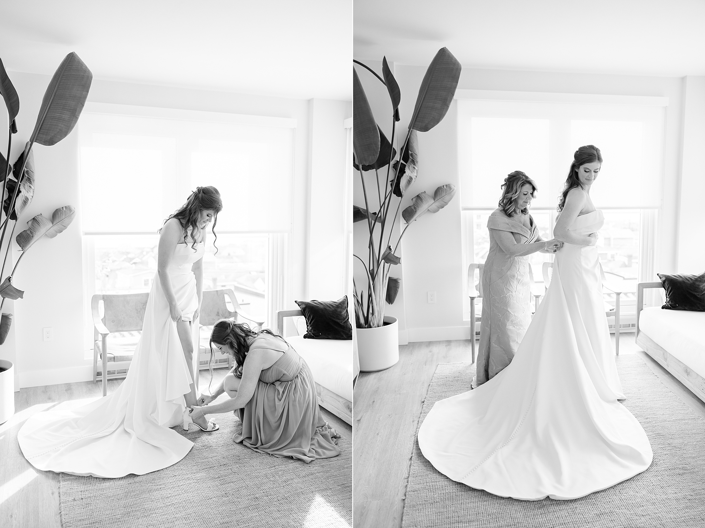 Bride getting ready with her mother, adjusting her dress and shoes in a bright room with large windows.