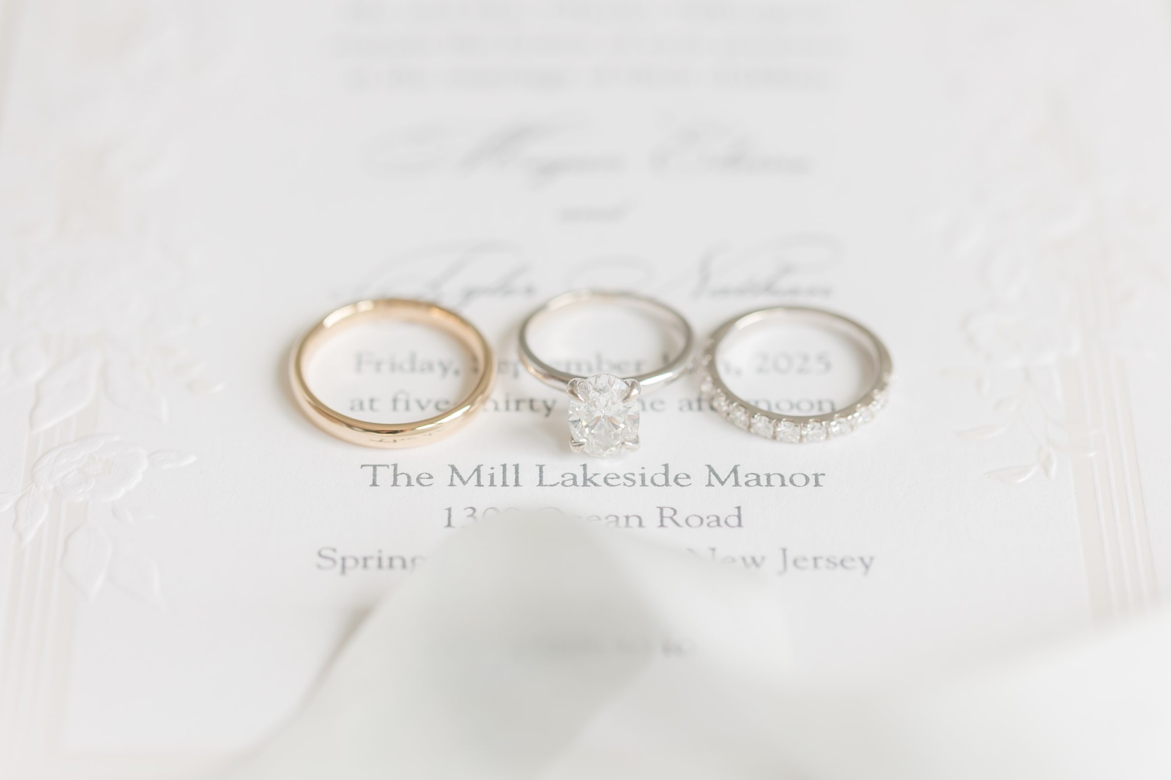 Wedding rings resting on an invitation suite, symbolizing commitment and the beginning of forever.