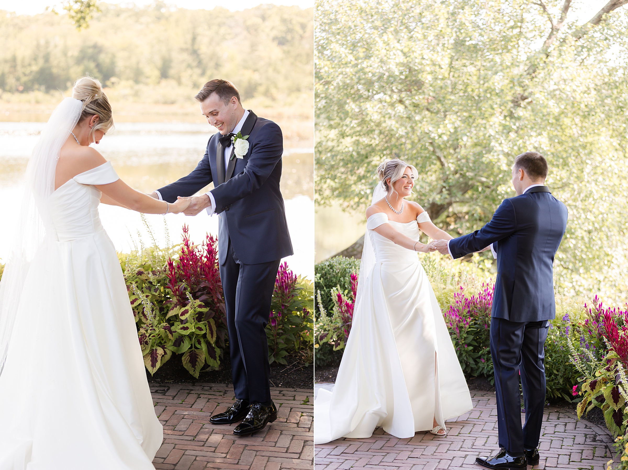 Bride and groom hold hands and gently spin together in a sunlit garden, sharing a joyful, romantic moment surrounded by blooming flowers and soft lakeside views.