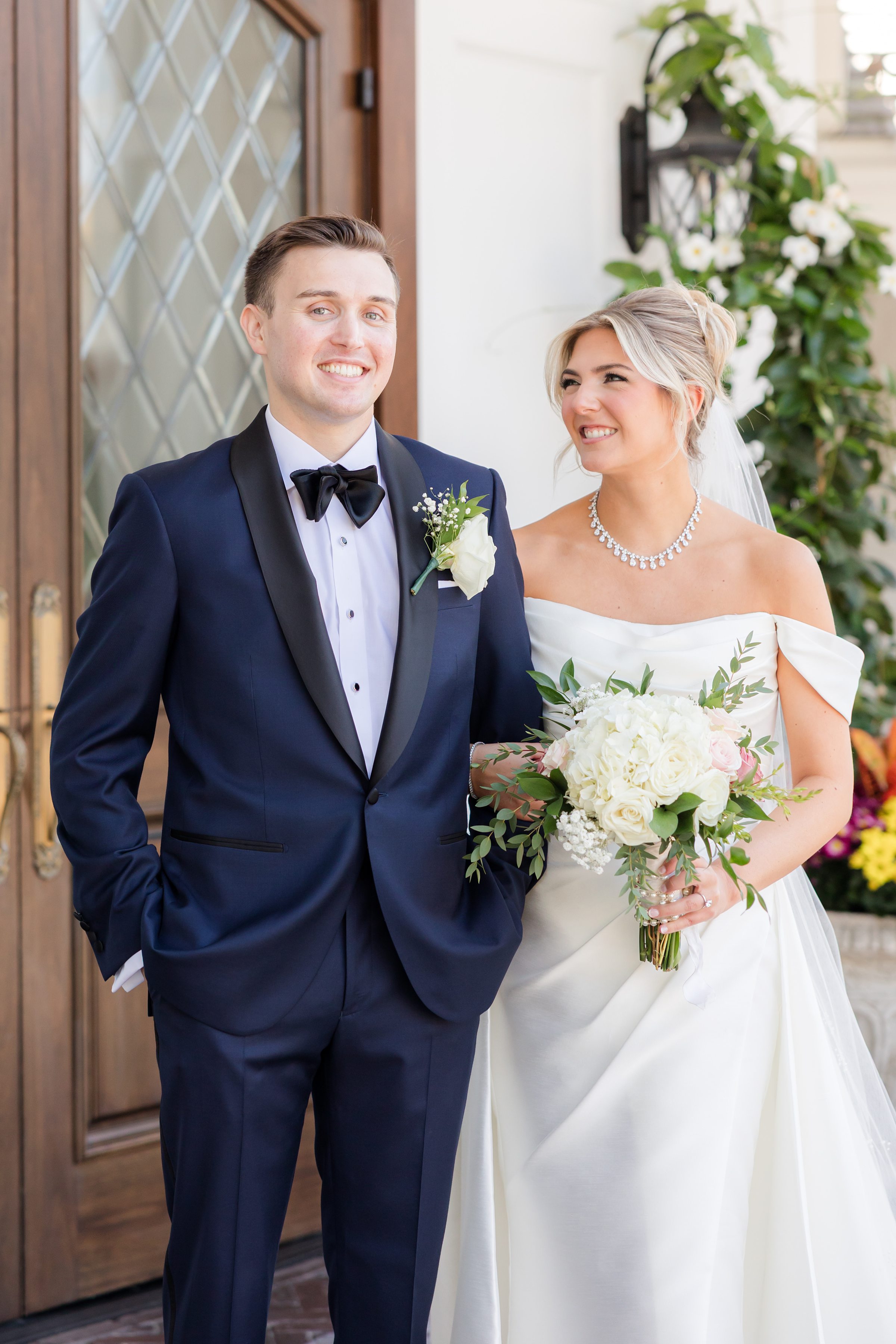 Bride and groom stand close together, smiling warmly on their wedding day.