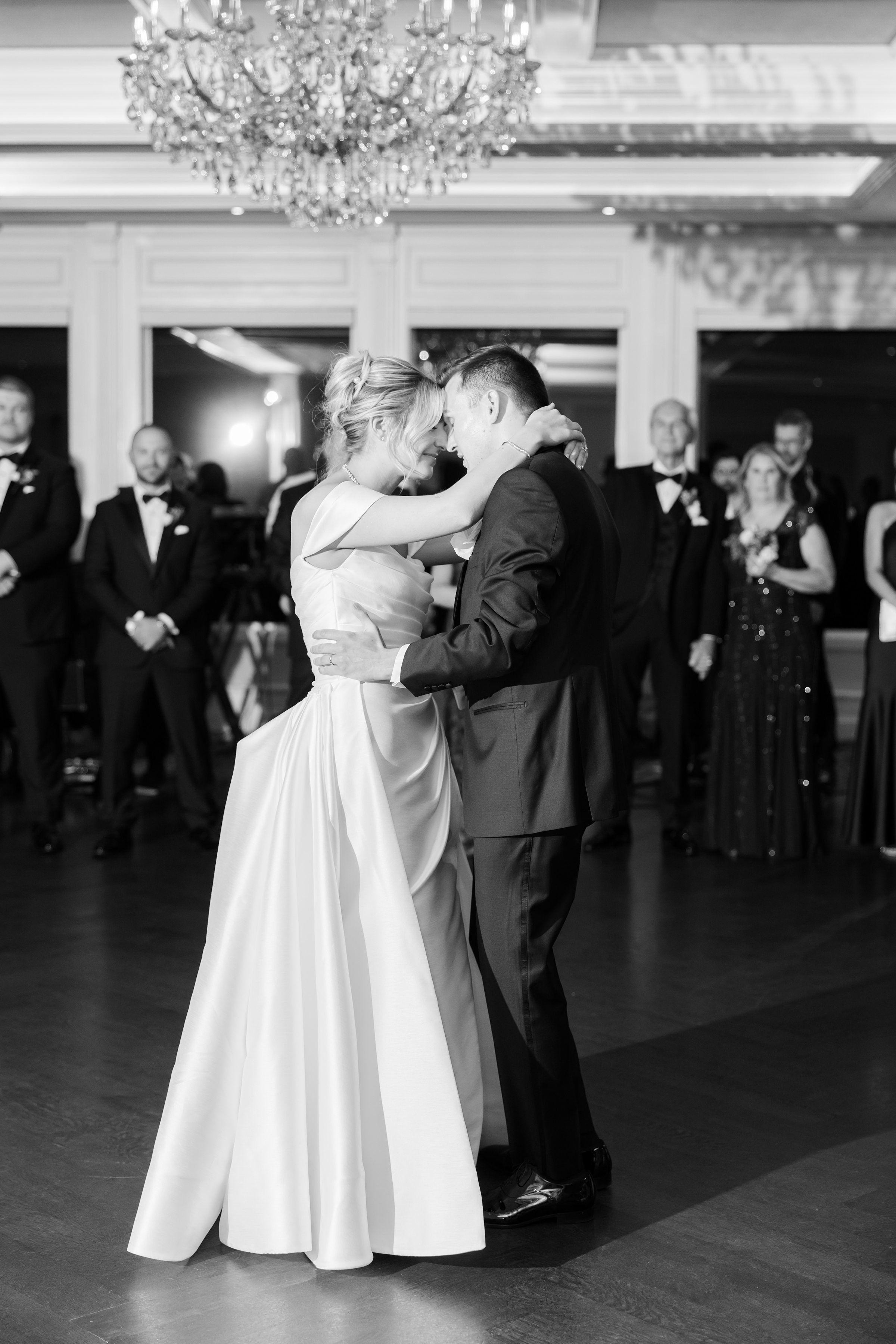 Bride and groom rest their foreheads together during a slow dance, lost in a deeply intimate and emotional moment.