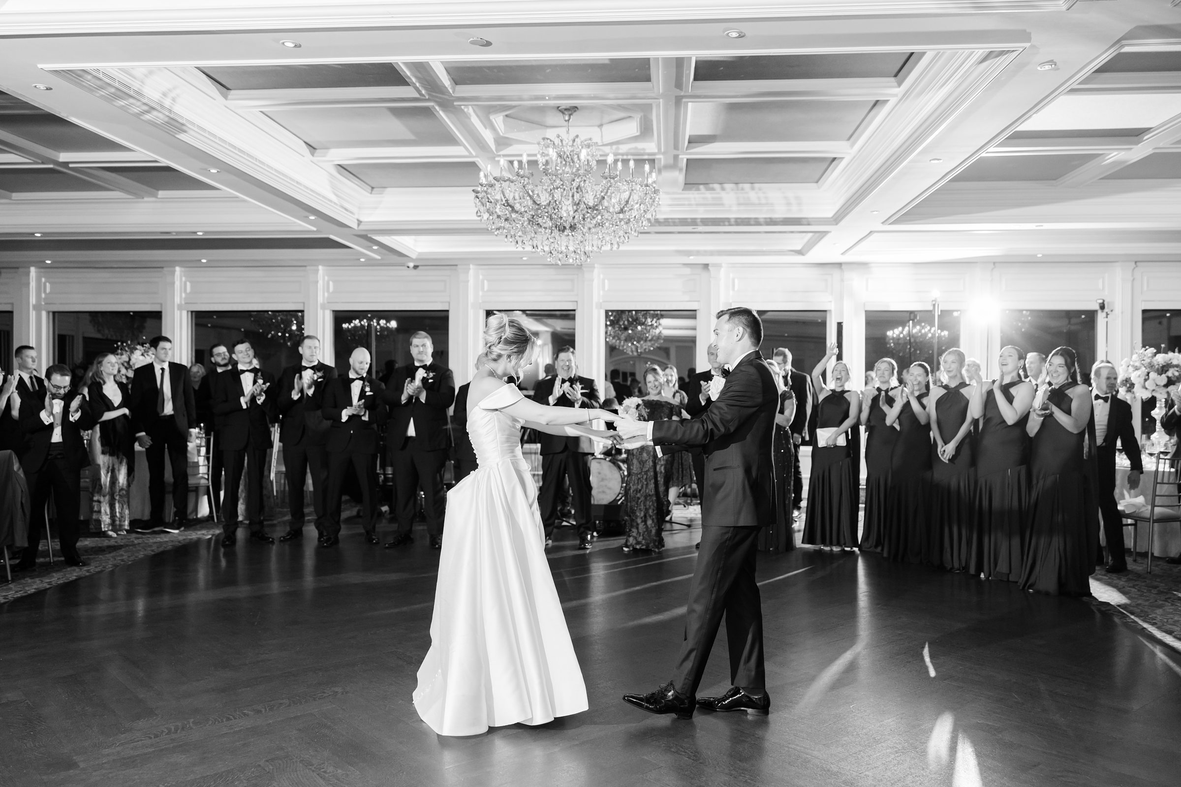 Surrounded by family and friends, the couple shares their first dance, holding each other close in a room filled with admiration and joy.