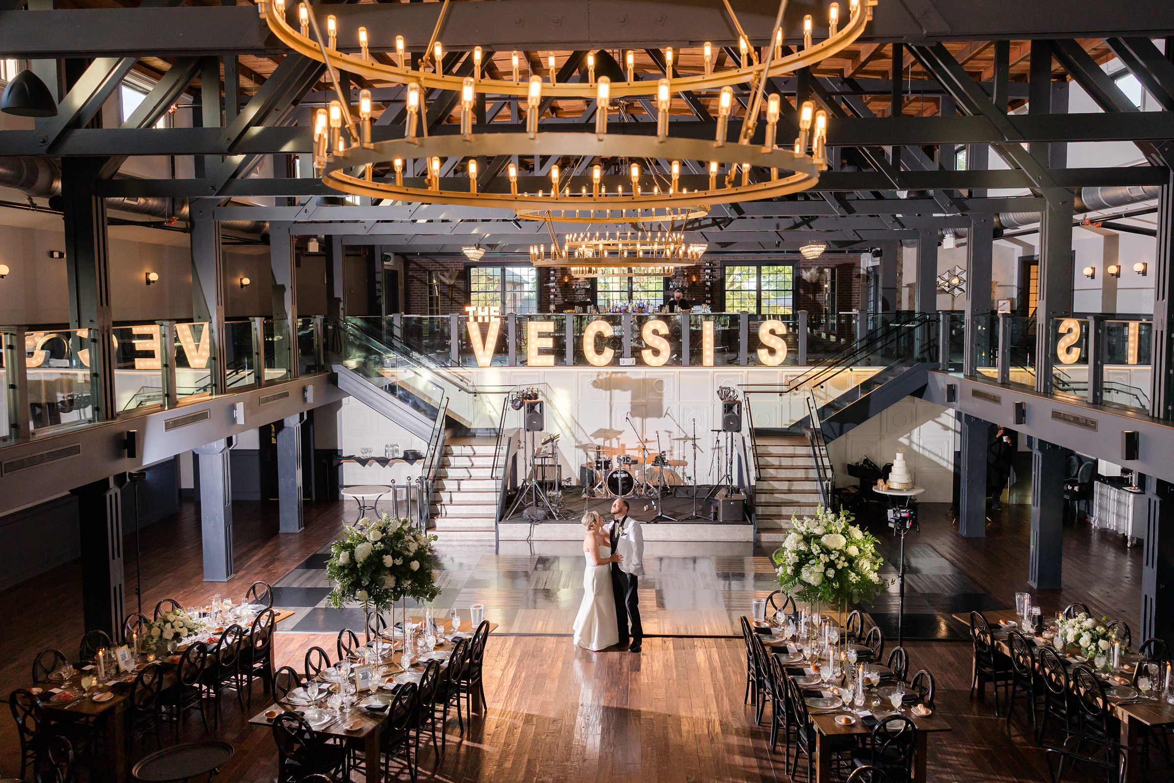 Bride and groom stand together at the heart of the room, surrounded by the beauty of their carefully designed celebration