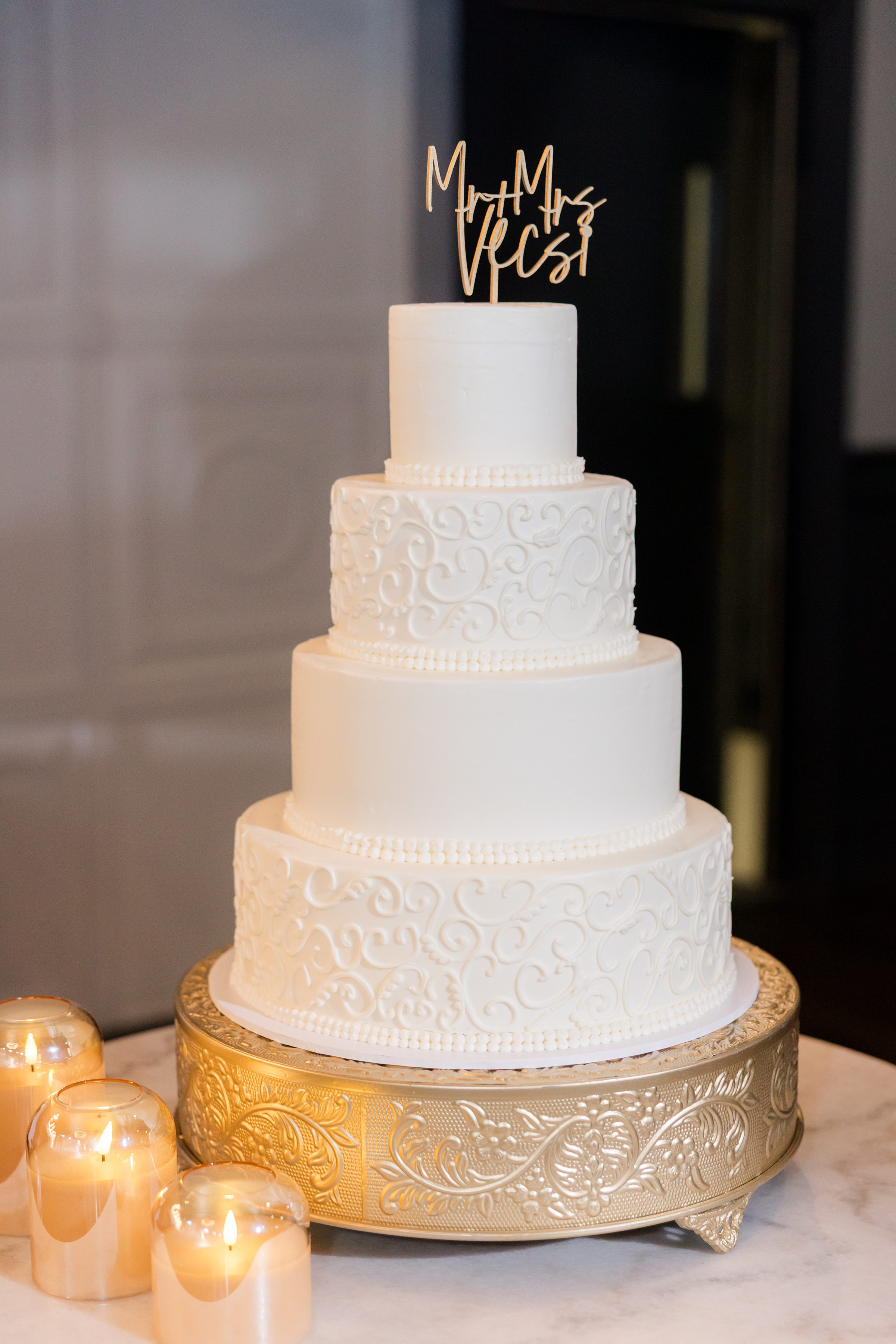 Elegant tiered wedding cake glows softly beside candlelight, symbolizing the sweetness of the couple’s union