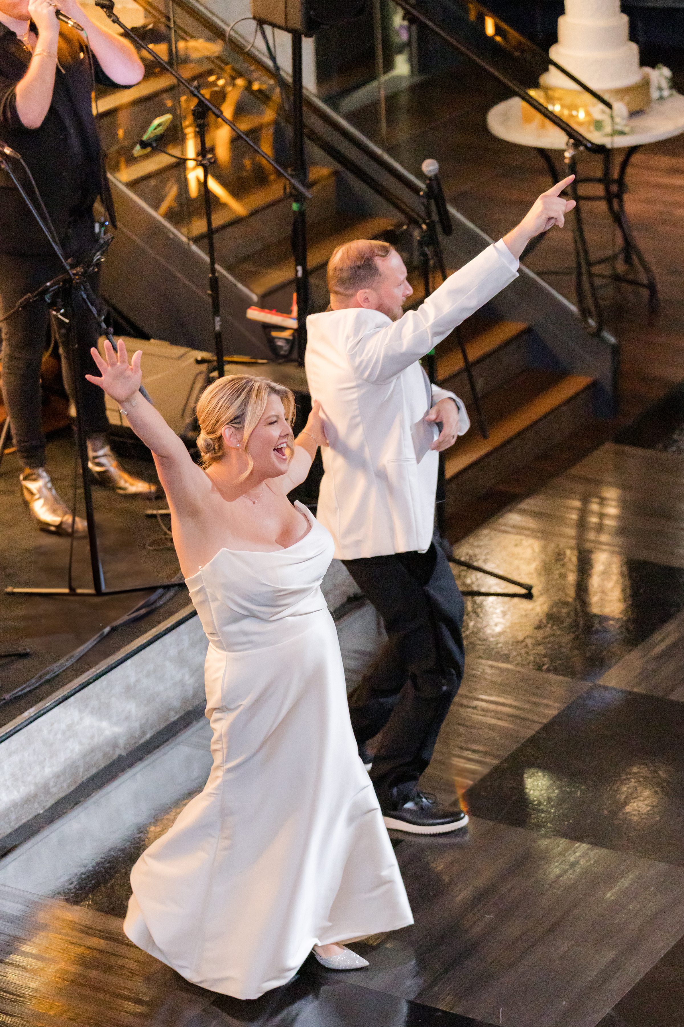 Bride spins with excitement while the groom dances beside her, both beaming with carefree joy.