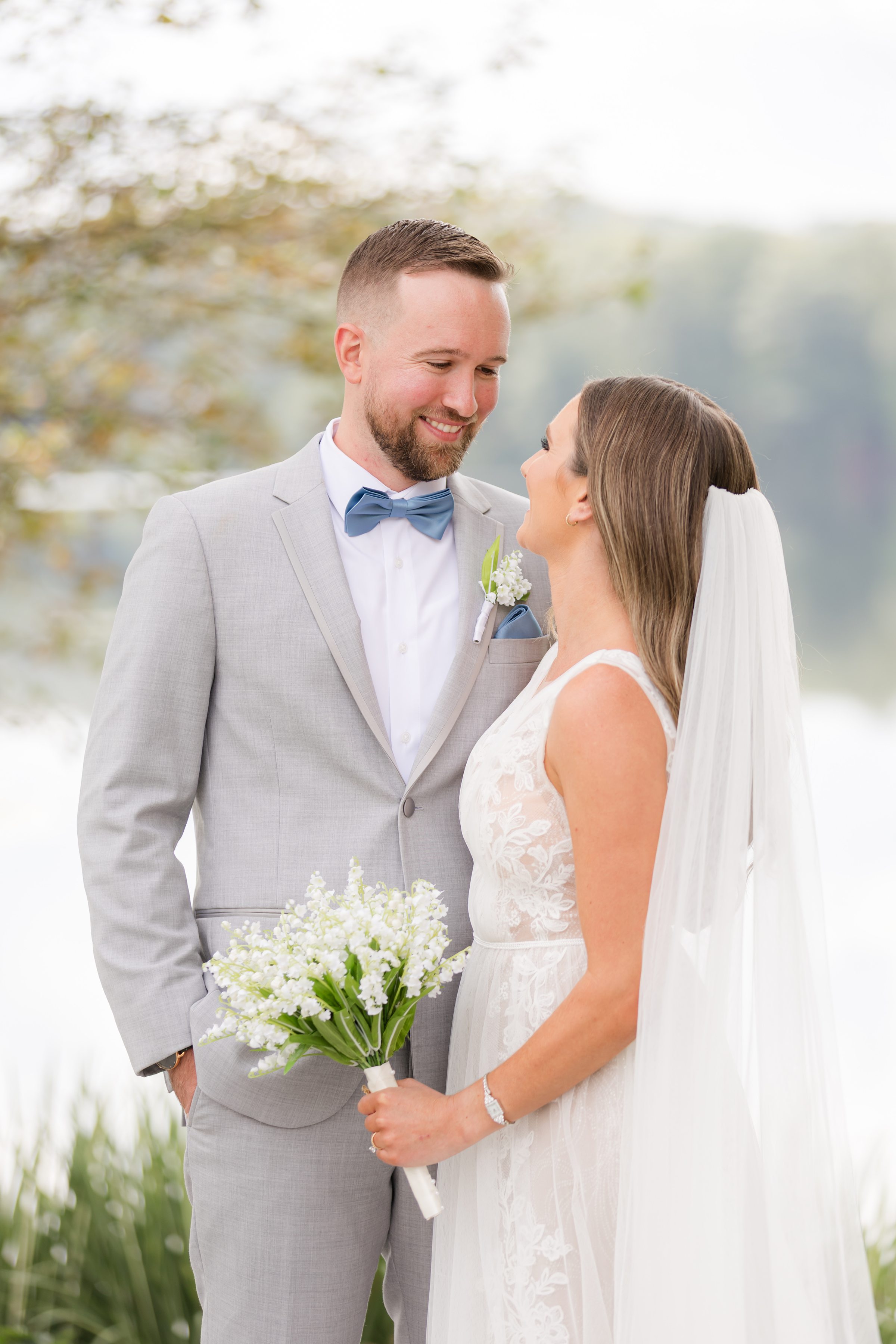 Groom gazes at his bride with a soft, adoring smile as she looks up at him, their hearts quietly intertwined in a moment of pure, effortless love
