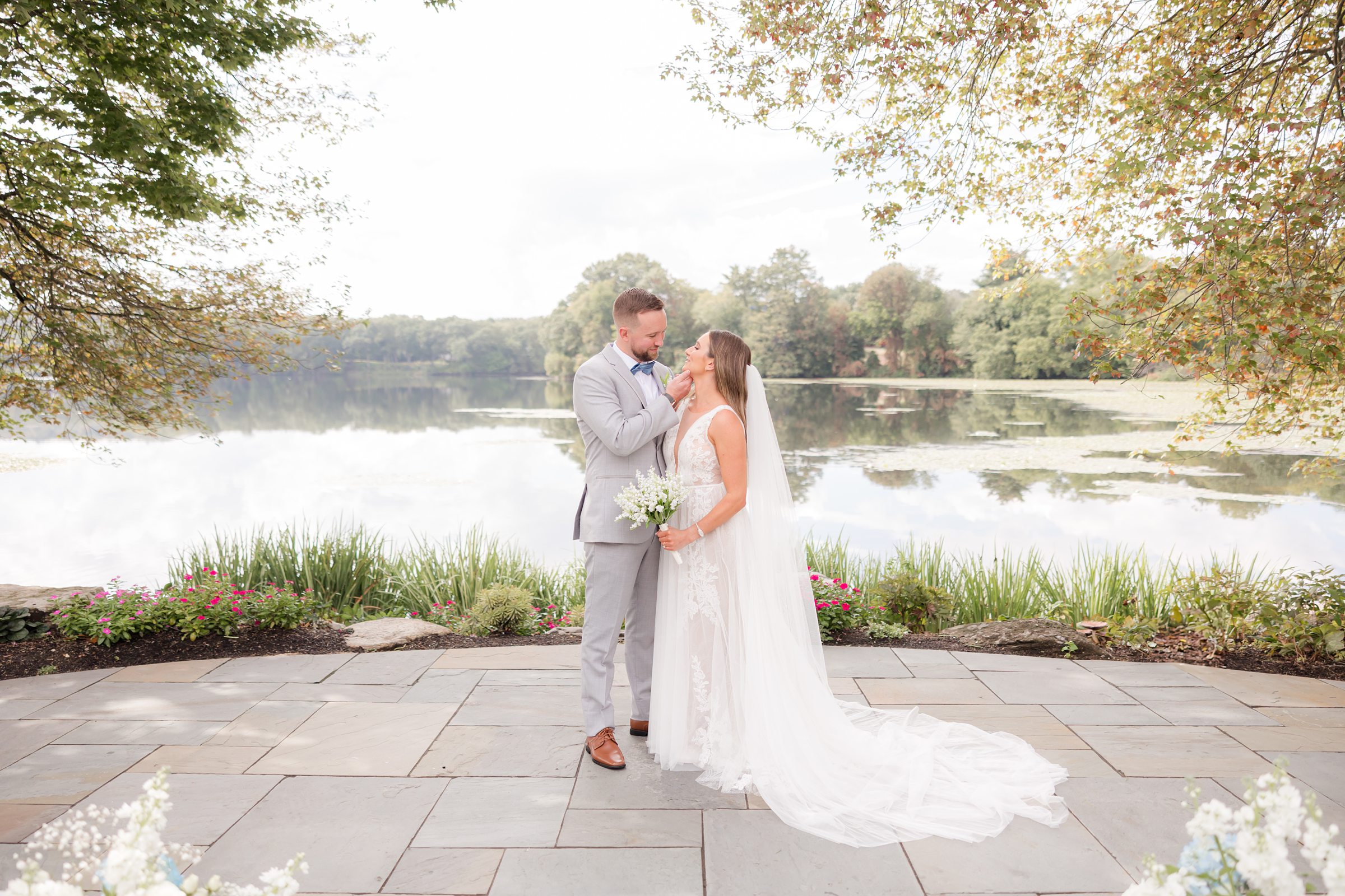 Bride and groom stand wrapped in each other’s arms, sharing a quiet, intimate moment as their love gently fills the air around them