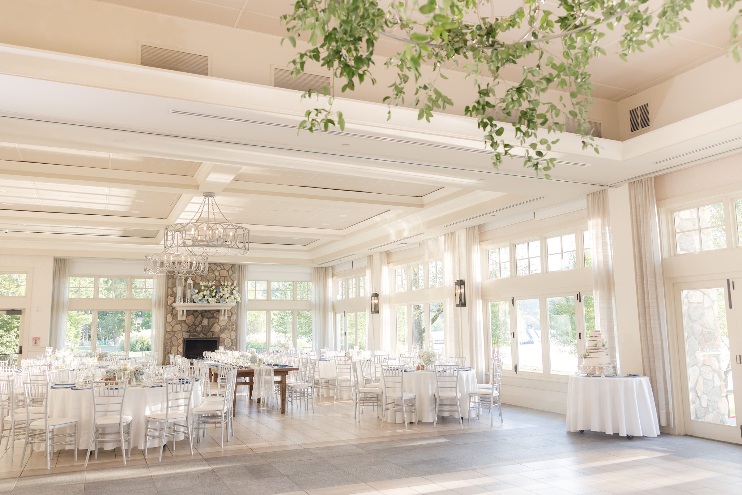 Reception hall glows with natural light and hanging greenery, ready to host a night of heartfelt moments