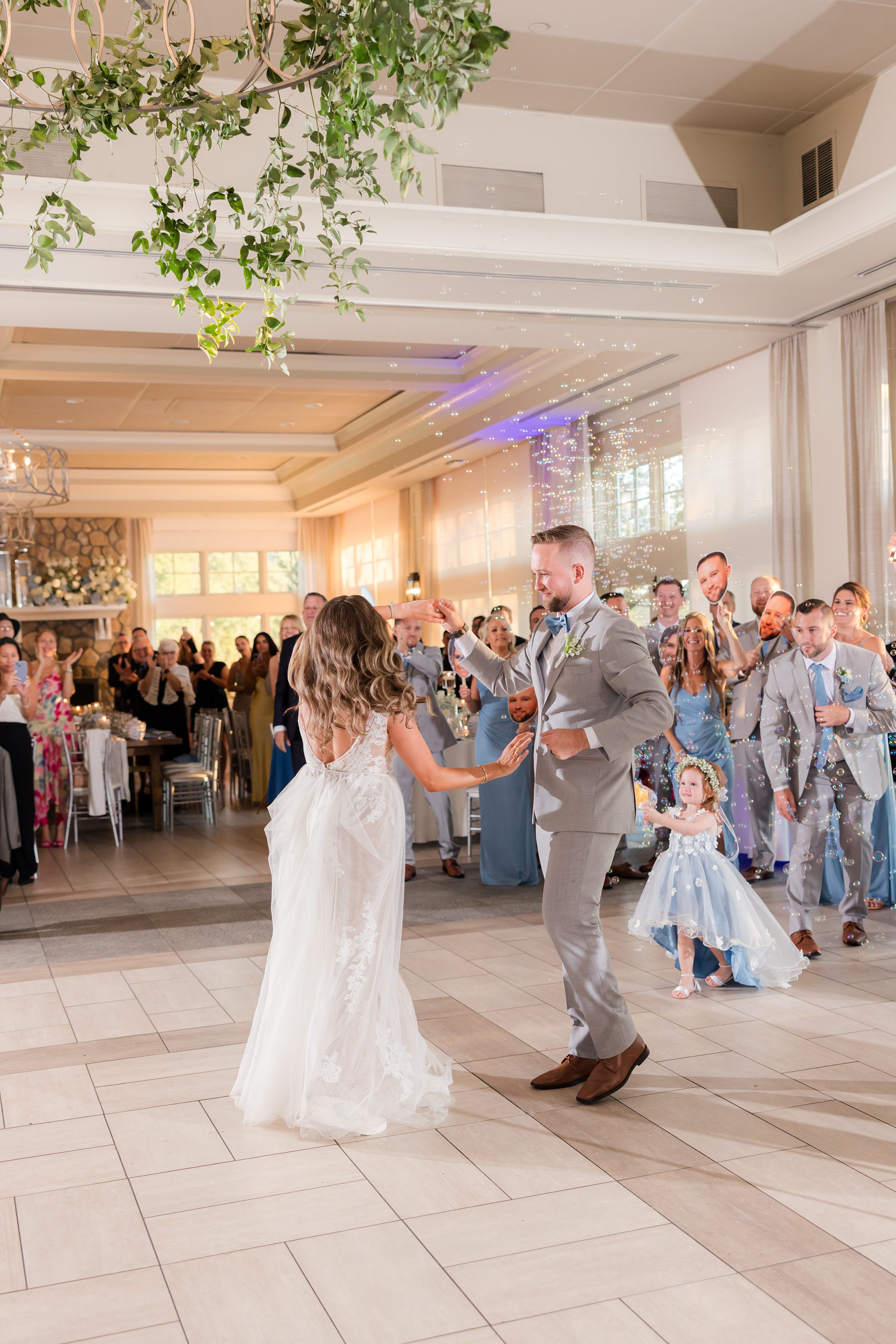 Bride twirls toward her groom as he reaches for her, their connection drawing smiles from the crowd