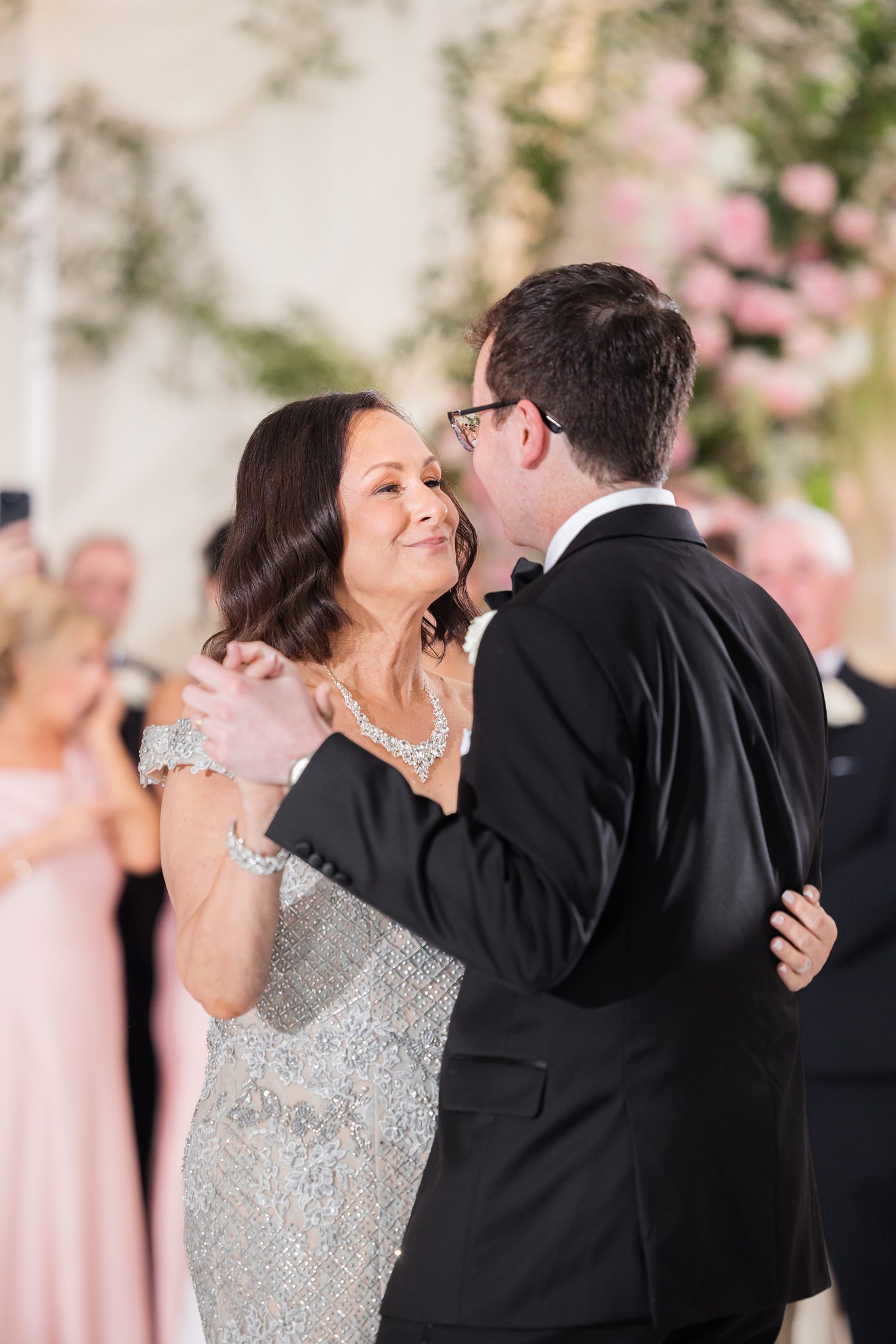 Intimate dance highlighting shared moment between groom and his mother surrounded by guests 