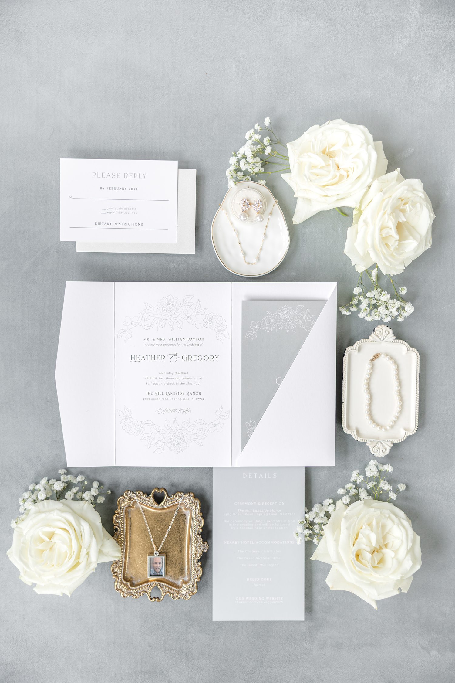 Muted gray wedding invitations with white flowers and gold accessories