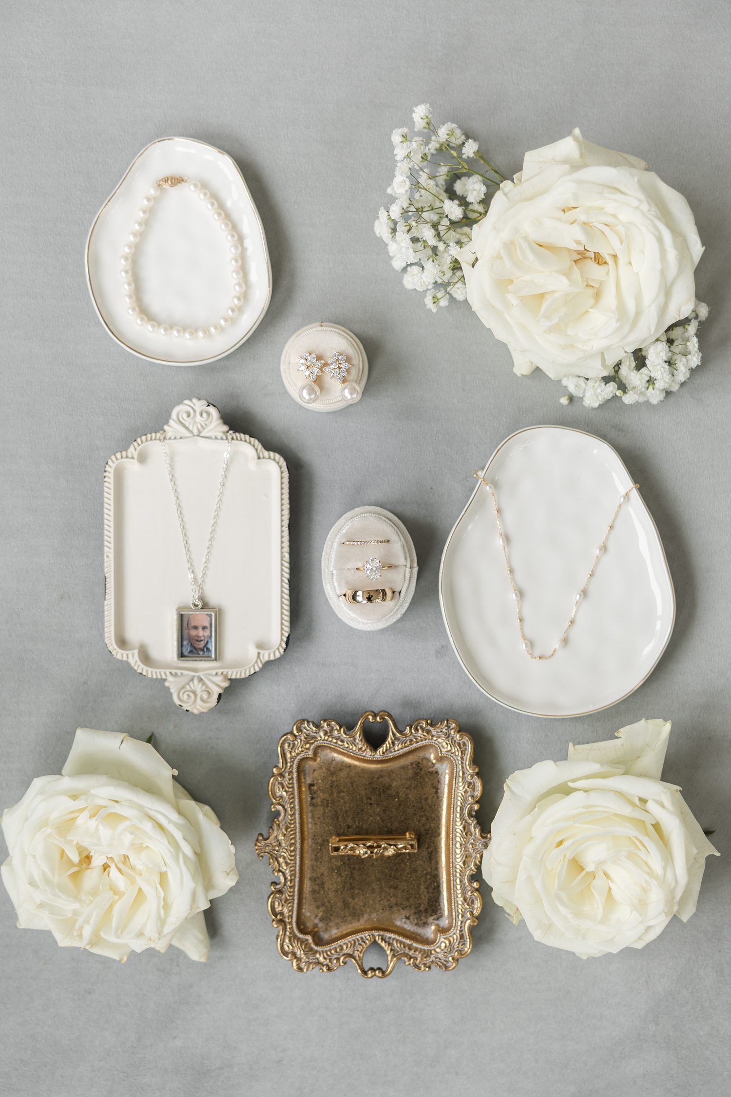 Bridal wedding details with vintage ring box, earrings, and white floral arrangement