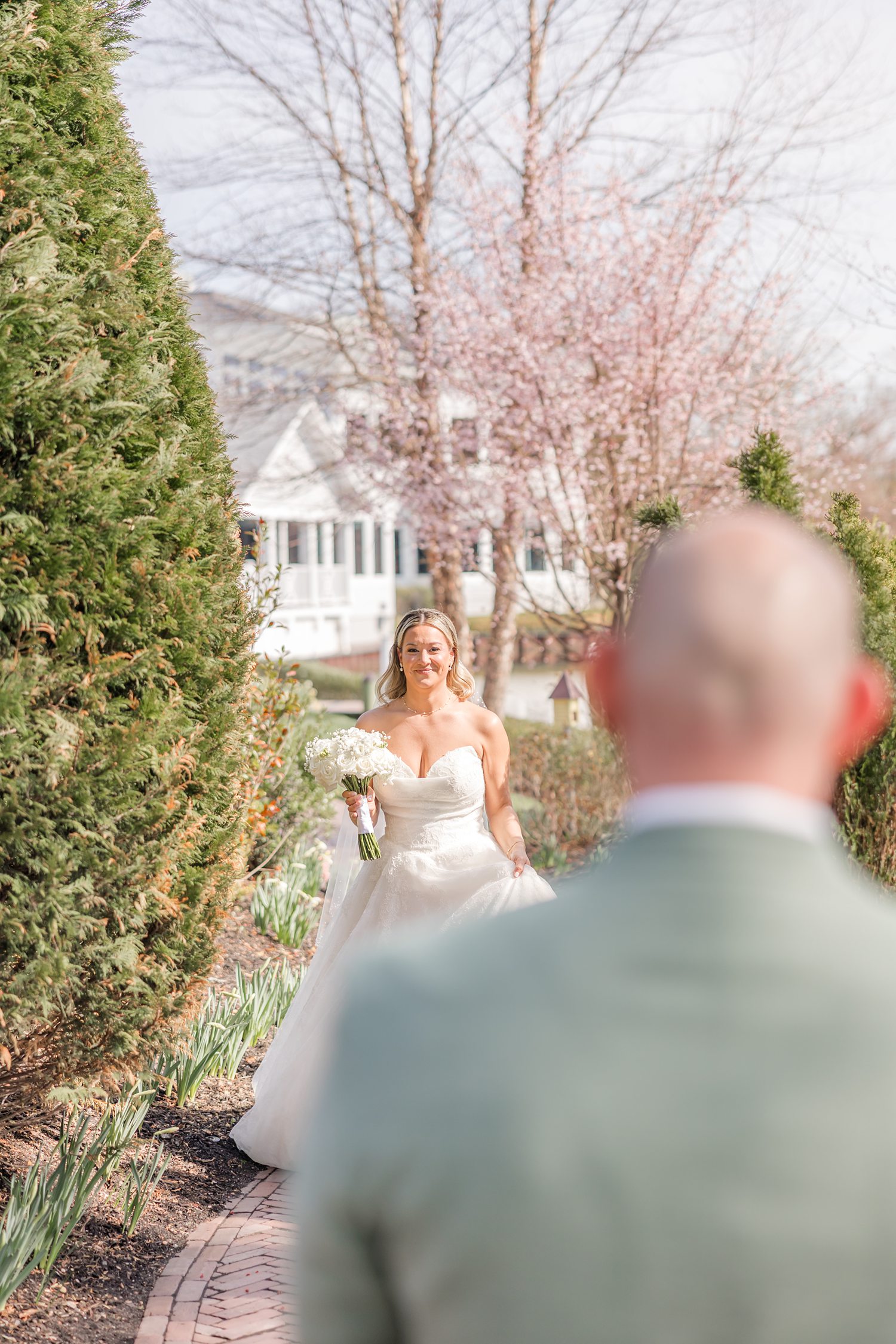 Bride walking toward groom during emotional outdoor first look moment