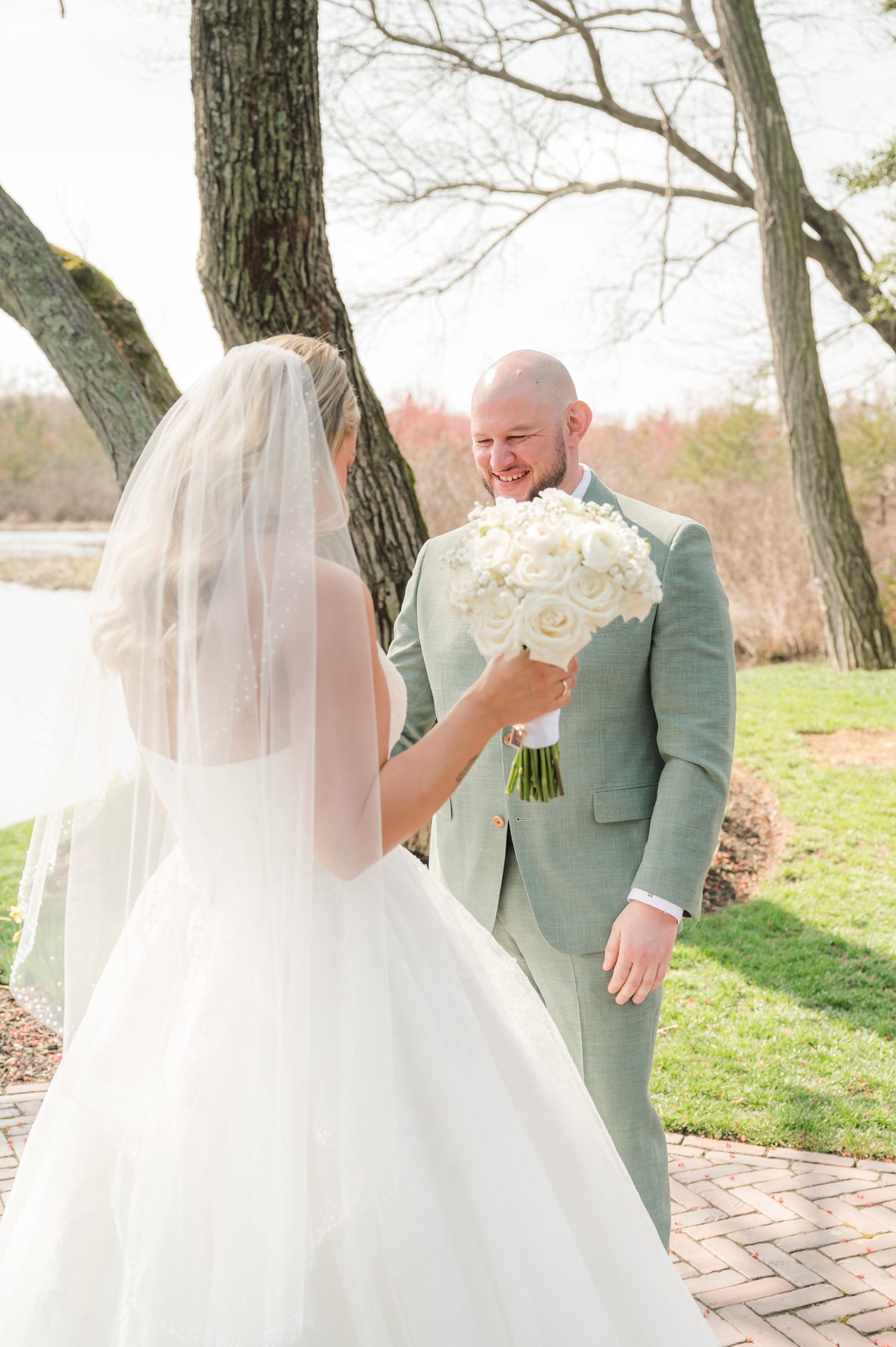 Bride and groom sharing intimate lakeside wedding portrait outdoors