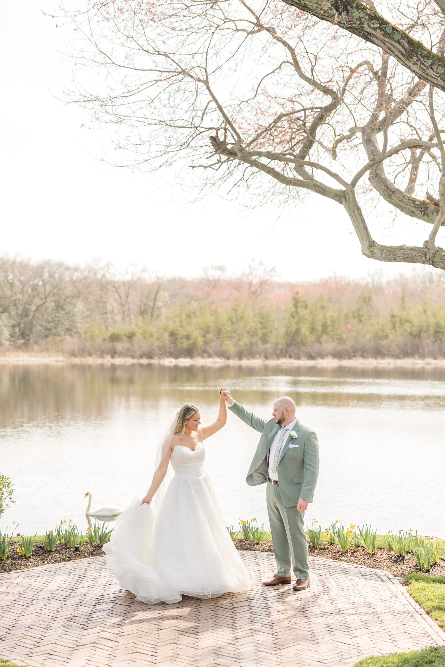 Bride and groom holding hands outdoors with scenic lakeside wedding backdrop